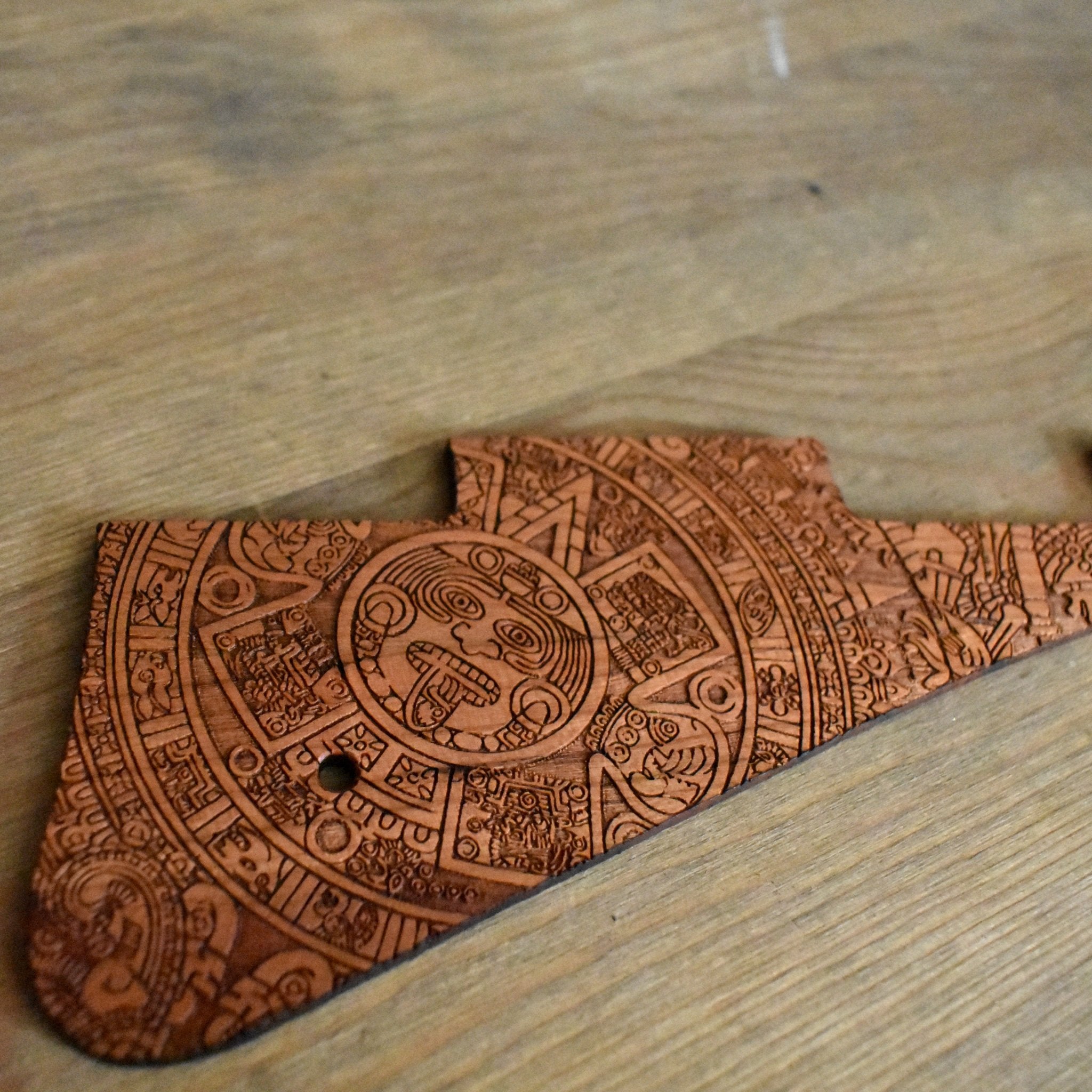 Detailed engraving of Aztec sunstone on custom Les Paul pickguard.