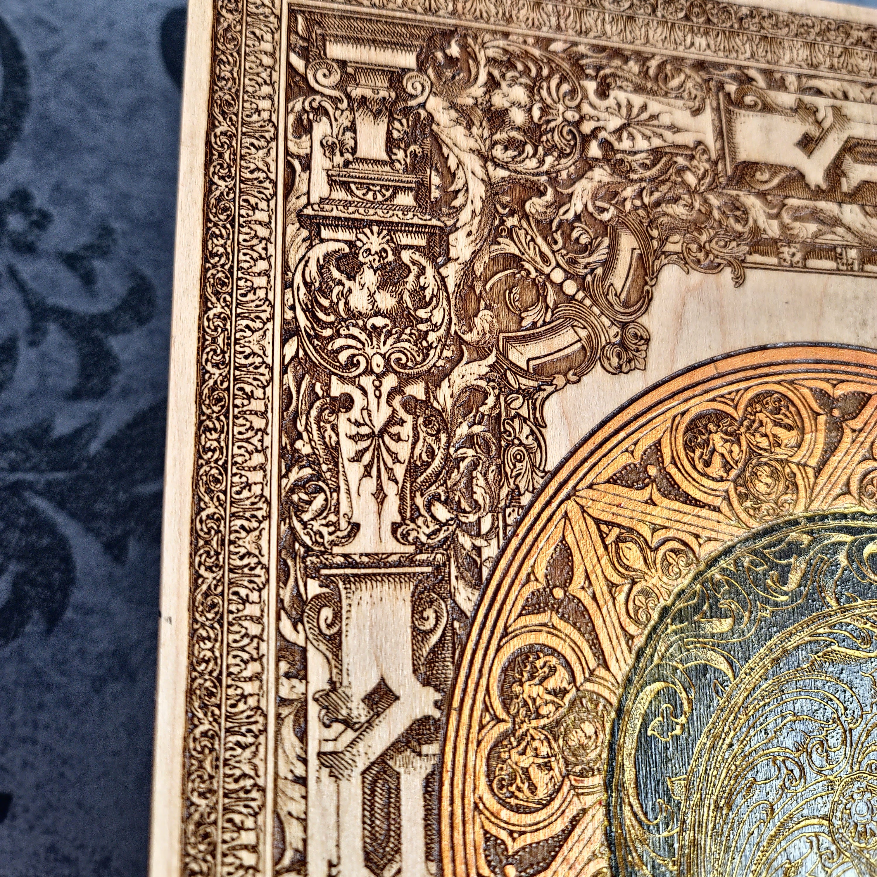 Black-and-gold medieval knight helmet maple wood wall art, close-up of the carved border and orange halo