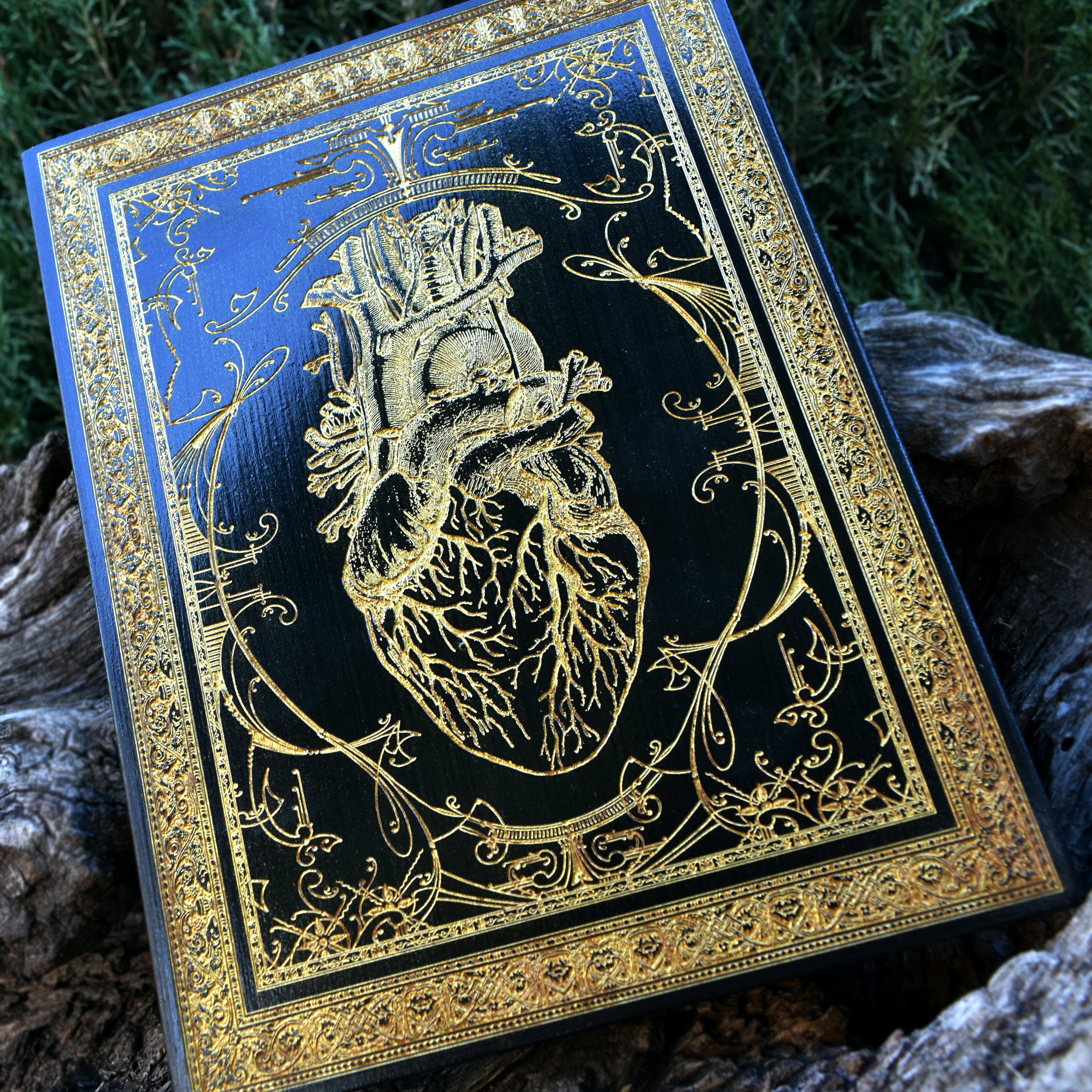 Close-up of anatomical heart wood art with black and gold design