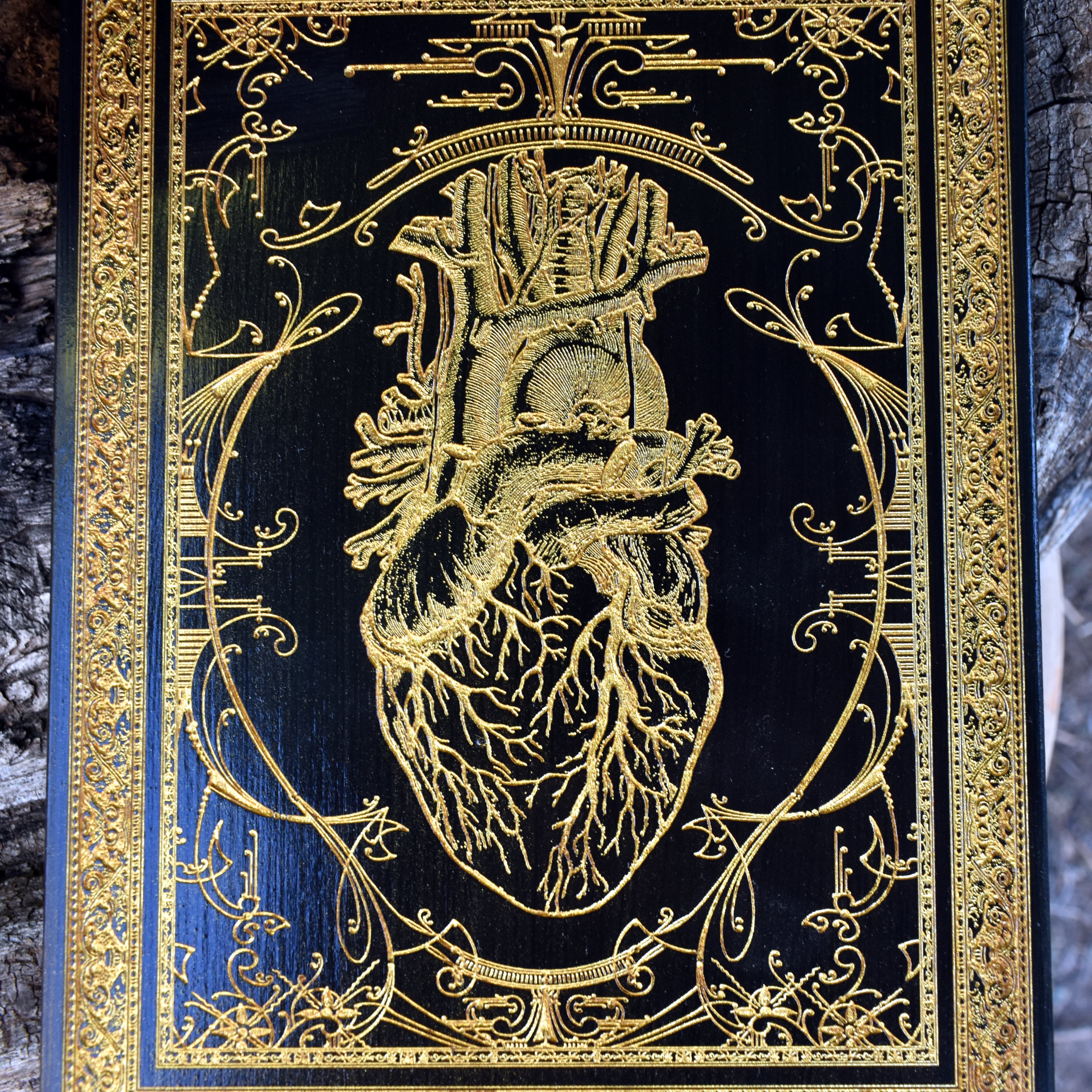 Wooden anatomical heart art with a striking black and gold finish