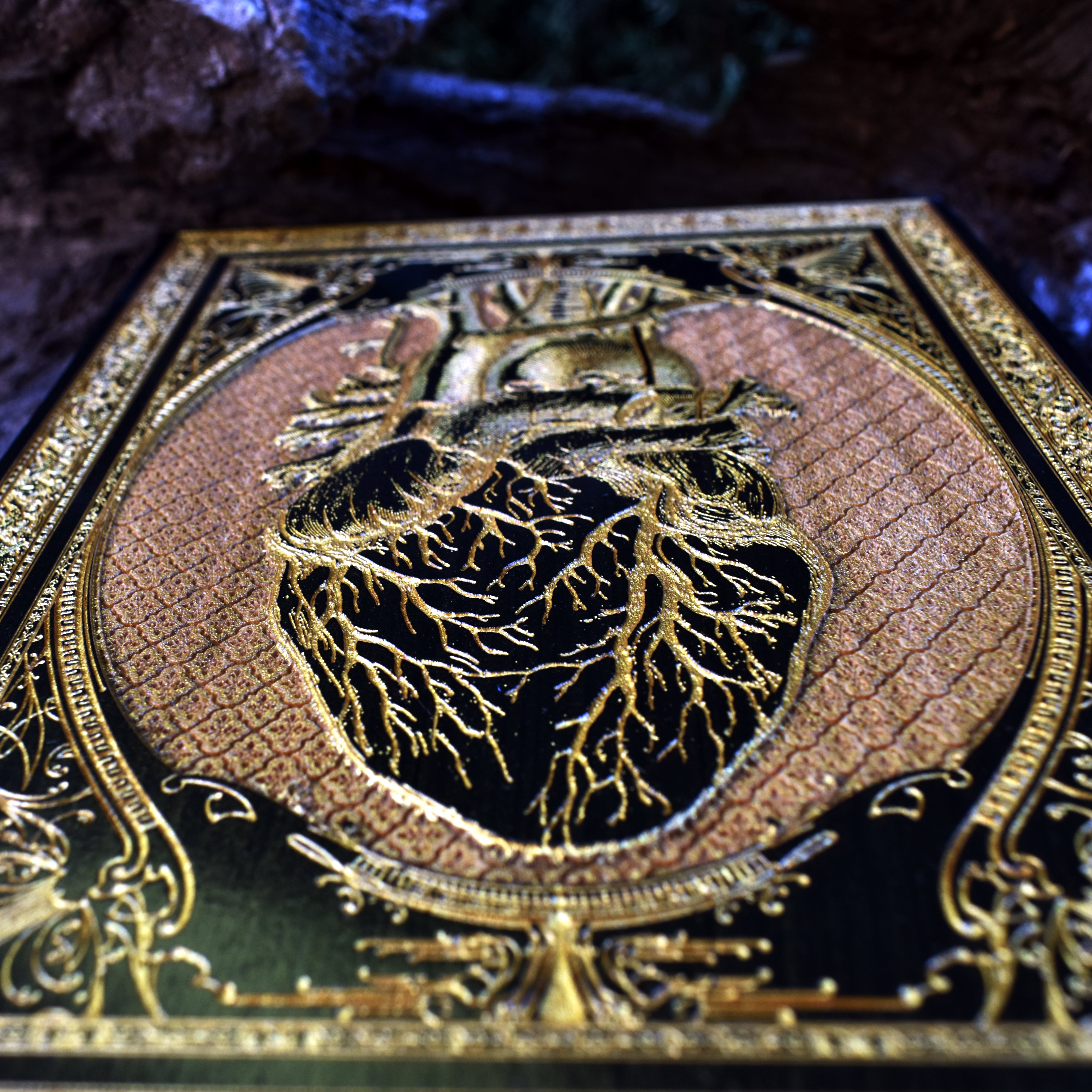 Anatomical heart with black and gold paint on wood, gothic-style artwork for home or office.