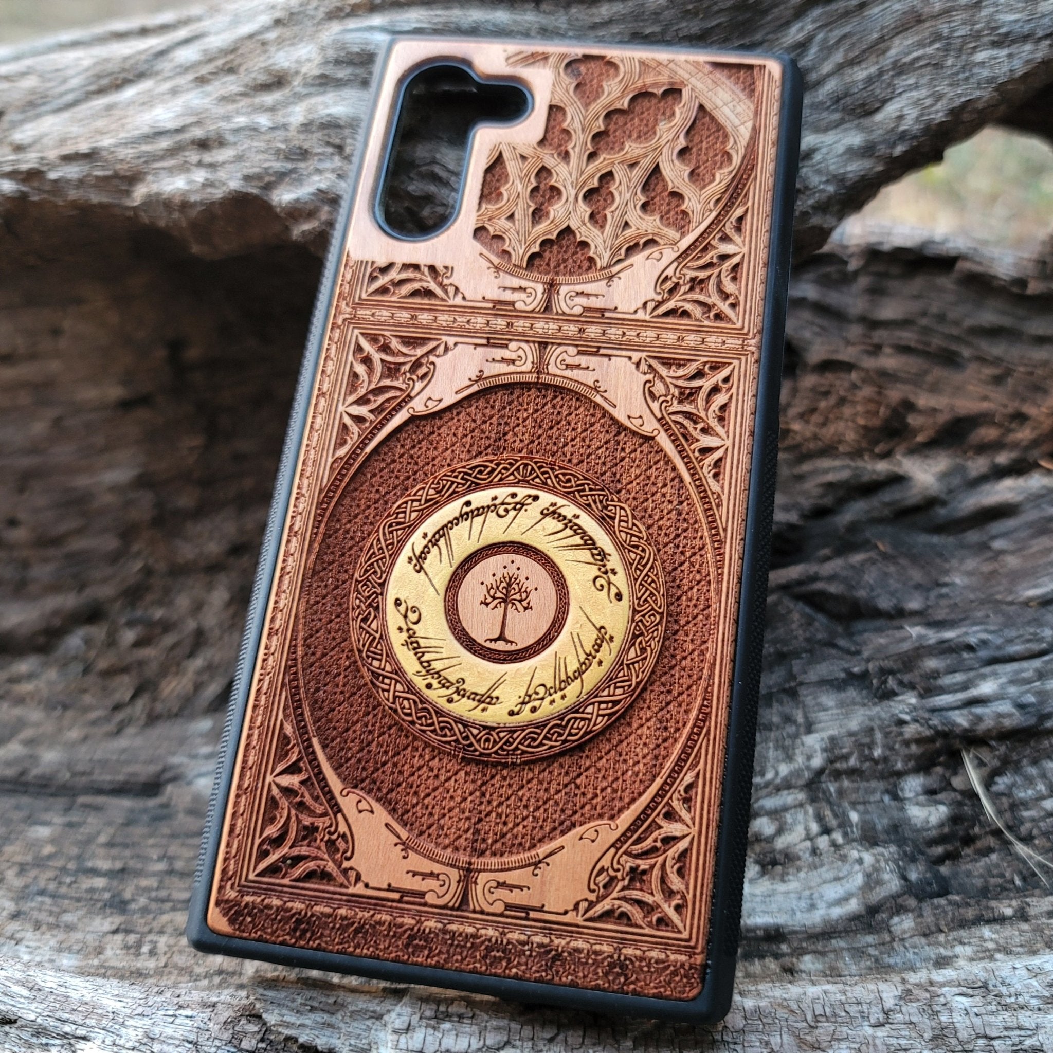 Close-up of intricate laser-engraved Tolkien-inspired design on handcrafted cherry wood phone case.