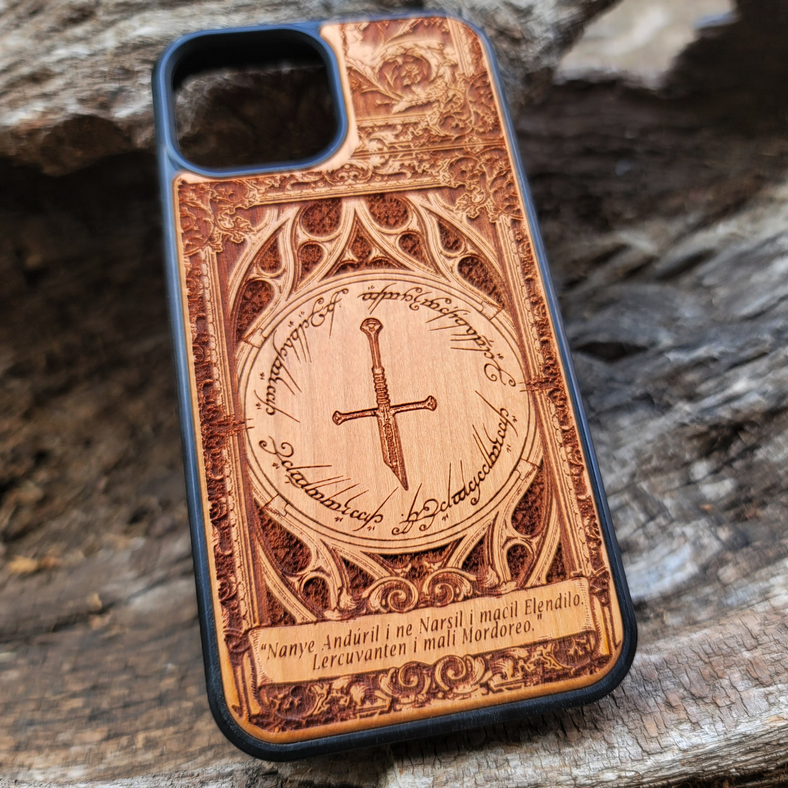 Lord of the Rings wood phone case featuring the Sword of Andúril, Elvish script, and a detailed ornate design. Laser-engraved with the quote 'Nanye Andúril i ne Narsil i macil Elendilo. Lercuvanten i mali Mordoreo.' This durable and artistic case is compatible with iPhone , 15, 14, 13, 12, 11, Pro Max, Mini, and Samsung Galaxy S, S24, S23, S22, S21, S20 Ultra, Plus, Note 20. A perfect protective accessory for Tolkien fans.