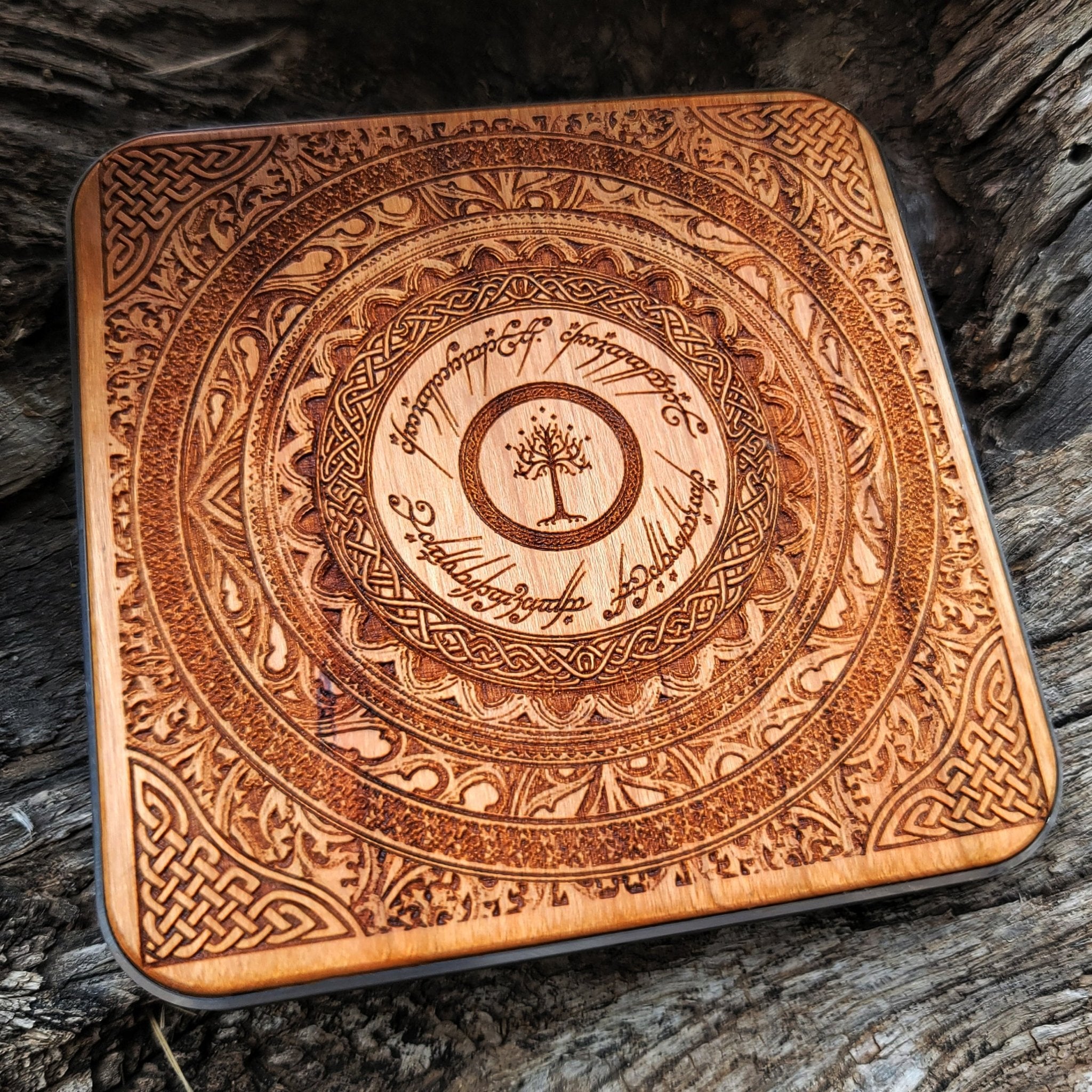 Artisan wood charger with Lord of the Rings-style carvings.