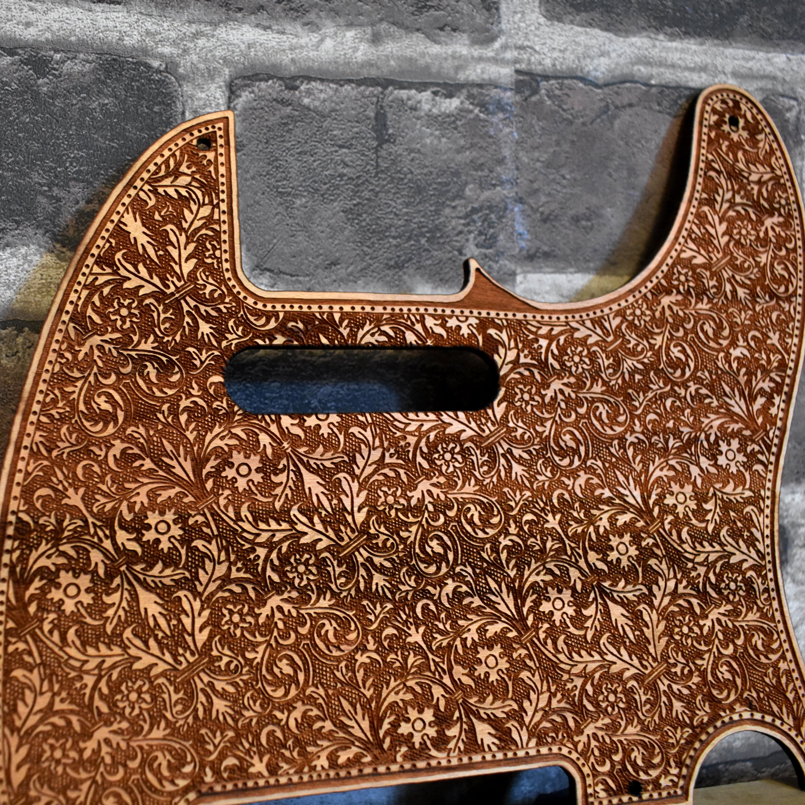 Close-up of handcrafted cherry wood pickguard for Fender Telecaster