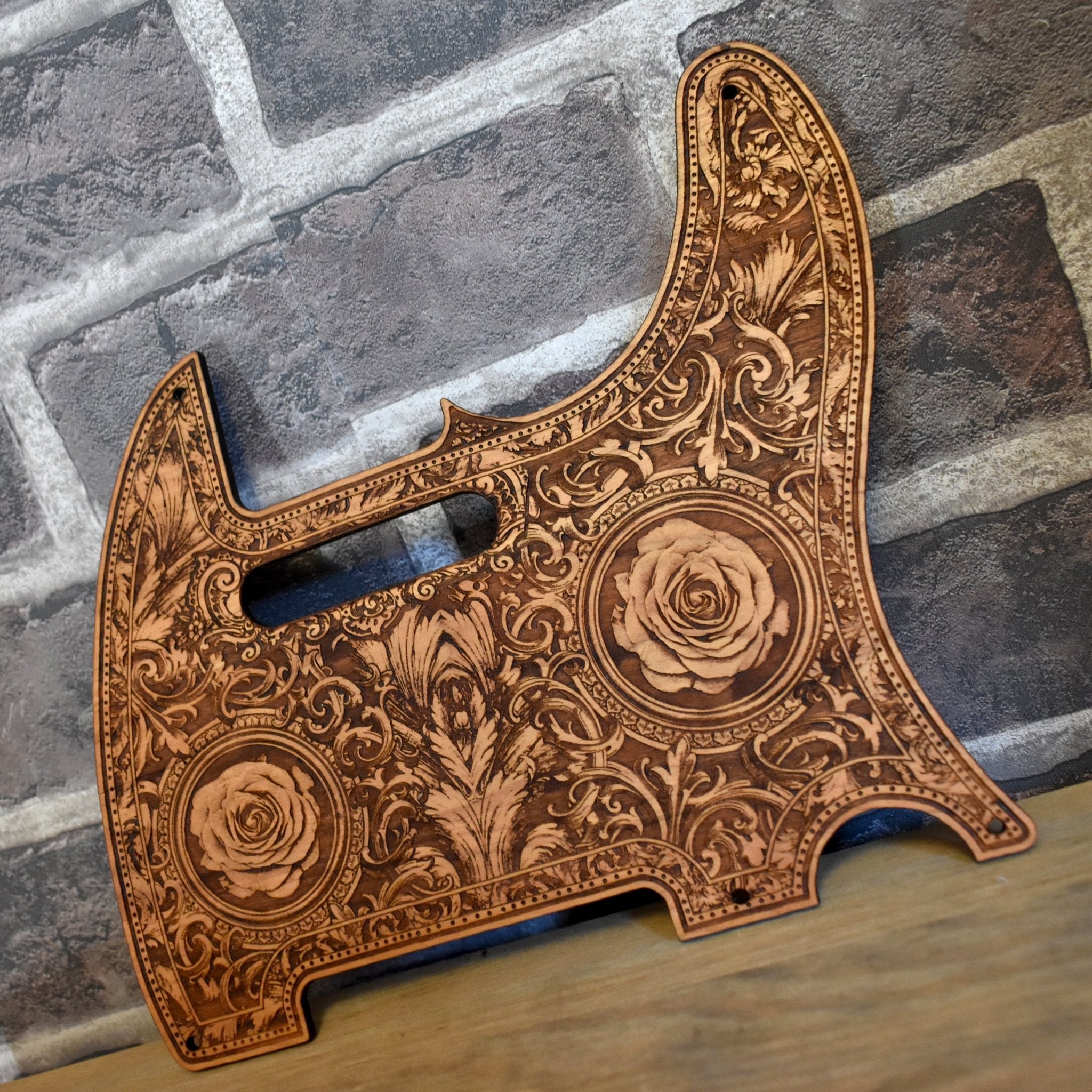 Close-up of hand-finished cherry wood pickguard for Fender Telecaster, laser-etched roses