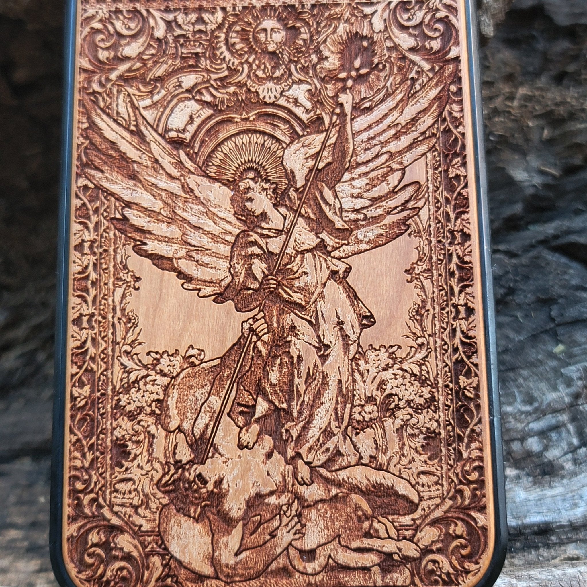 Wood phone case featuring religious artwork of Saint Michael the Archangel, engraved for iPhone  and Samsung Galaxy S with intricate detailing of the archangel defeating the devil.