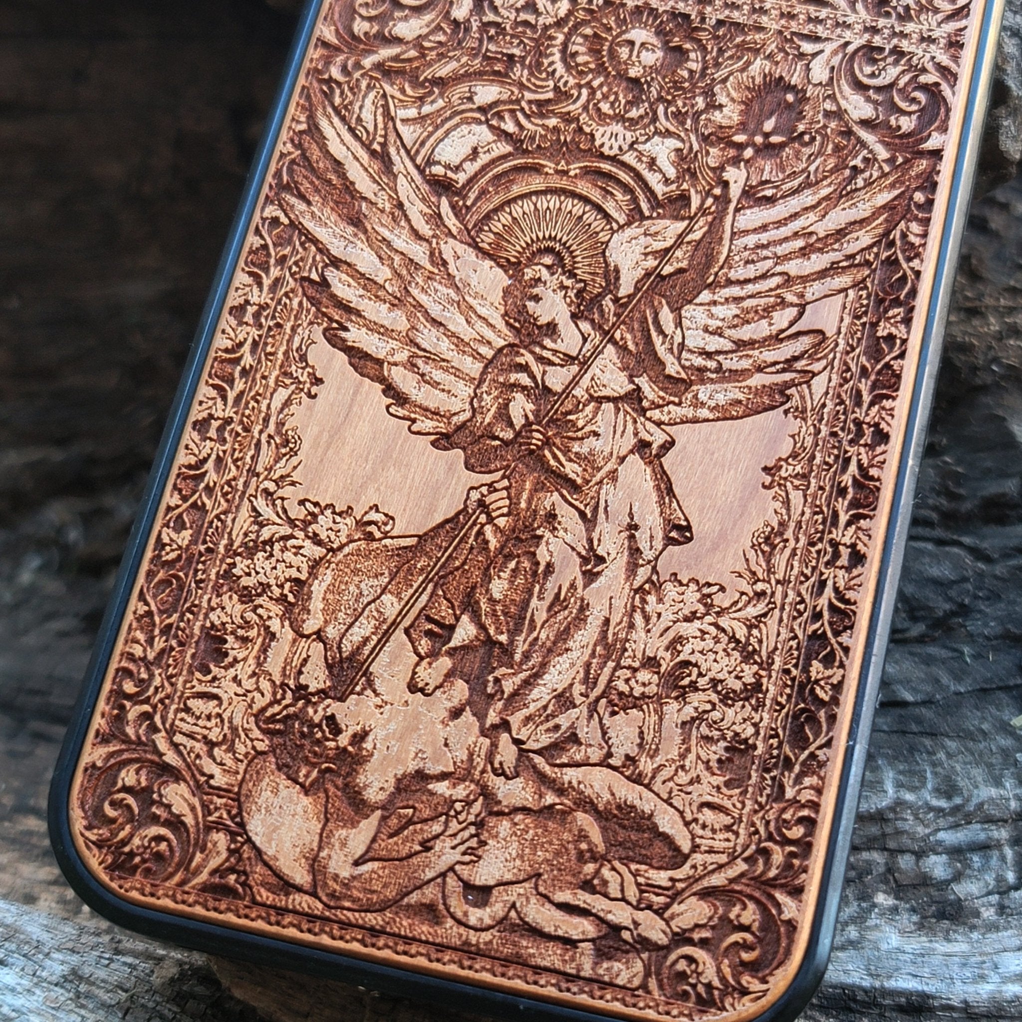 Wood phone case featuring religious artwork of Saint Michael the Archangel, engraved for iPhone  and Samsung Galaxy S with intricate detailing of the archangel defeating the devil.