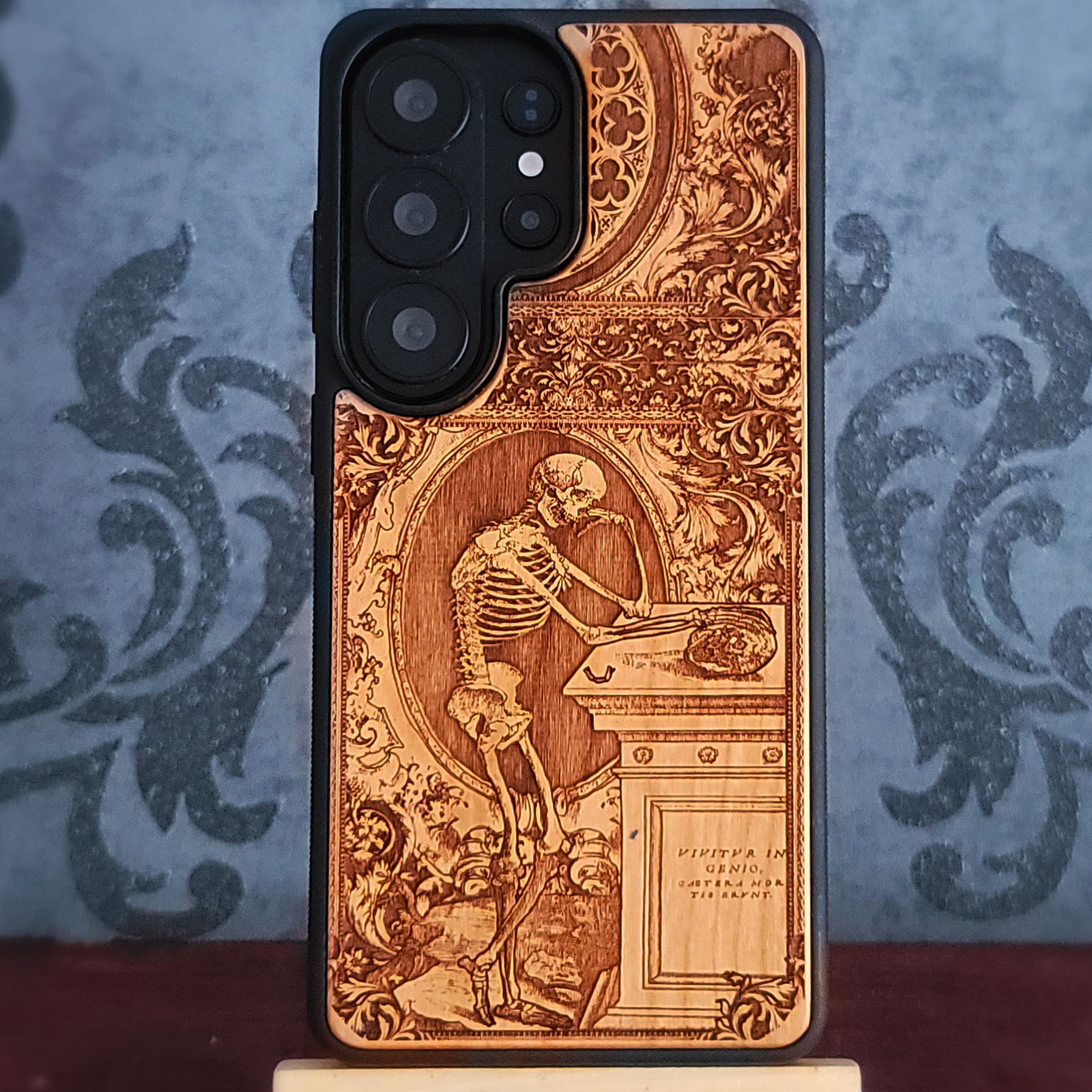 Laser-engraved wooden phone case with a gothic skeleton thinker design, perfect for iPhone and Samsung Galaxy.