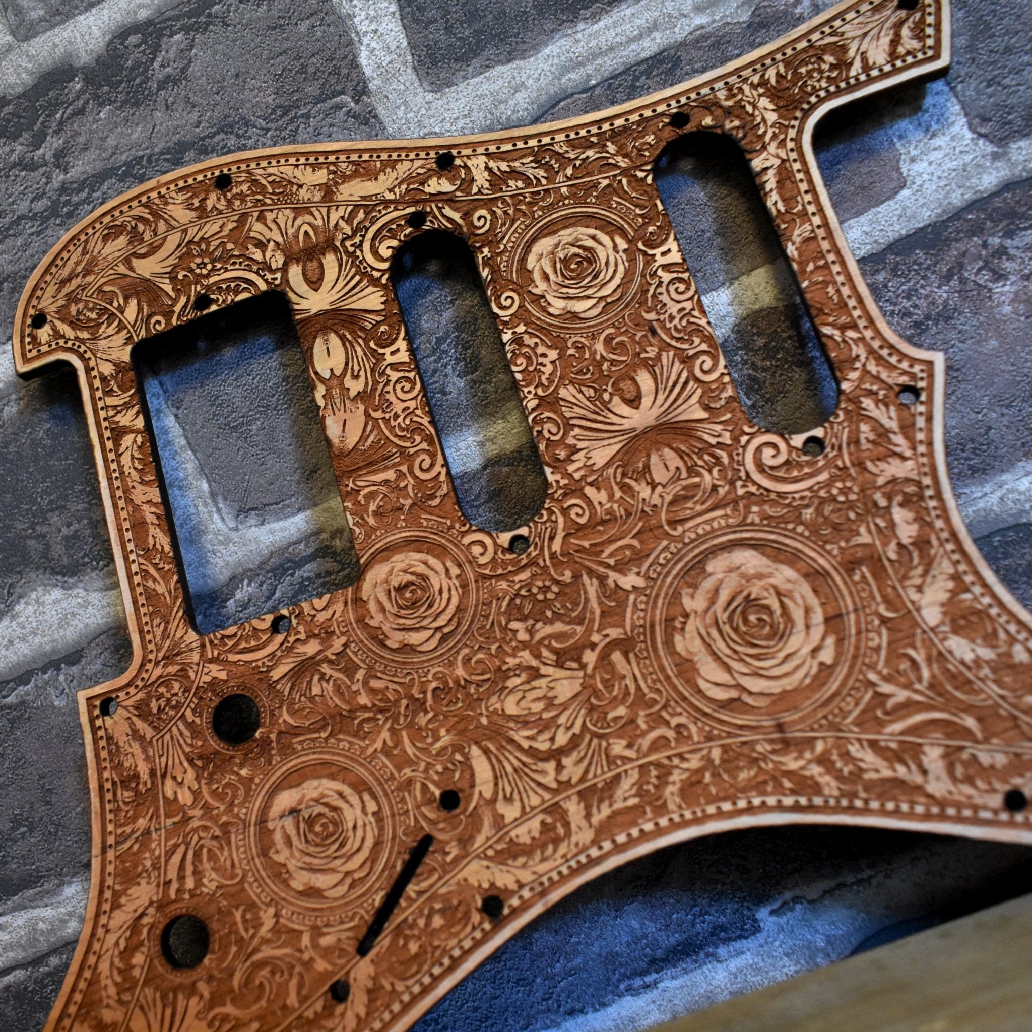 Close-up of laser engraved roses artwork on cherry wood pickguard