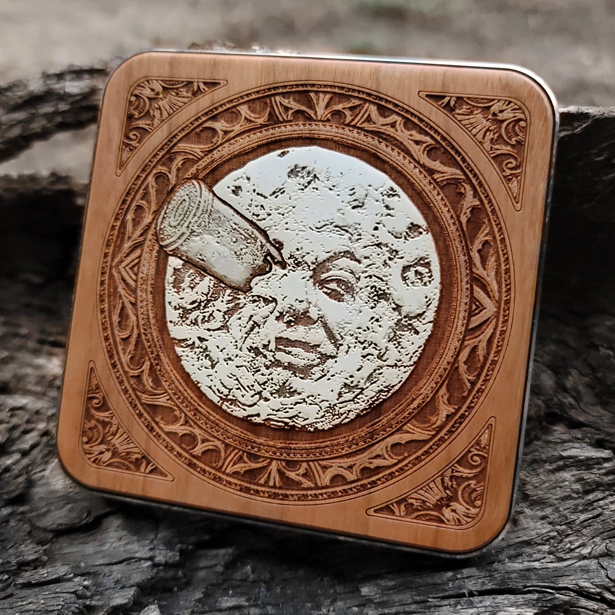 Close-up of hand-painted moon face on wooden wireless charger.