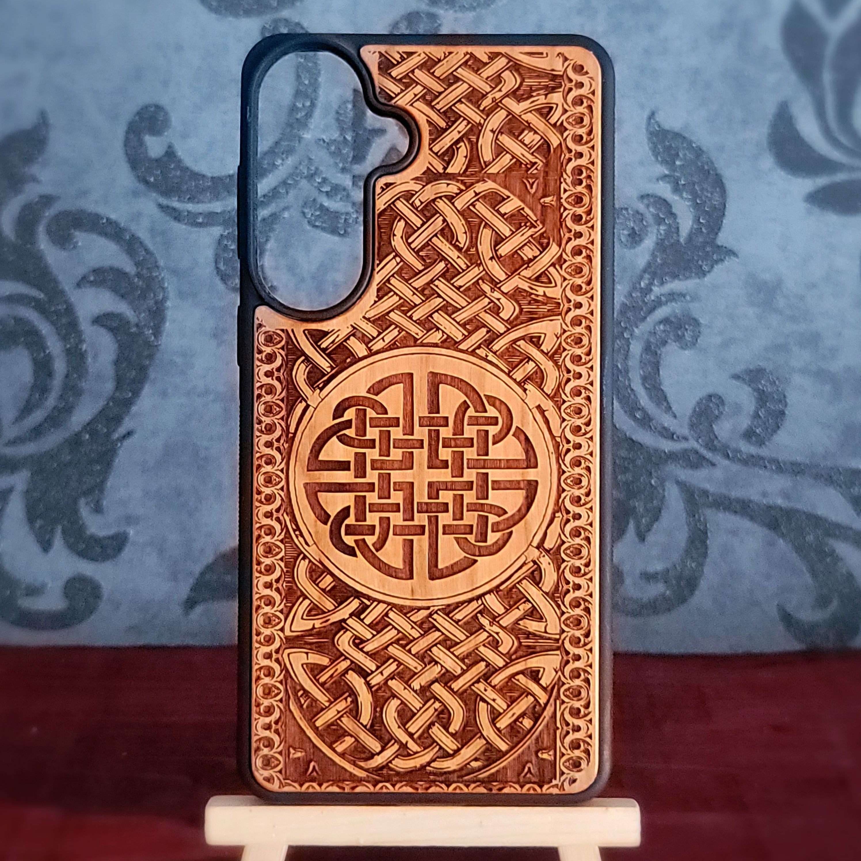 Handcrafted wooden phone case featuring a laser-engraved Celtic Knot design. Perfect for lovers of Celtic art and unique accessories. Compatible with iPhone 17-11 Pro Max and Galaxy S26-S20 Ultra models.