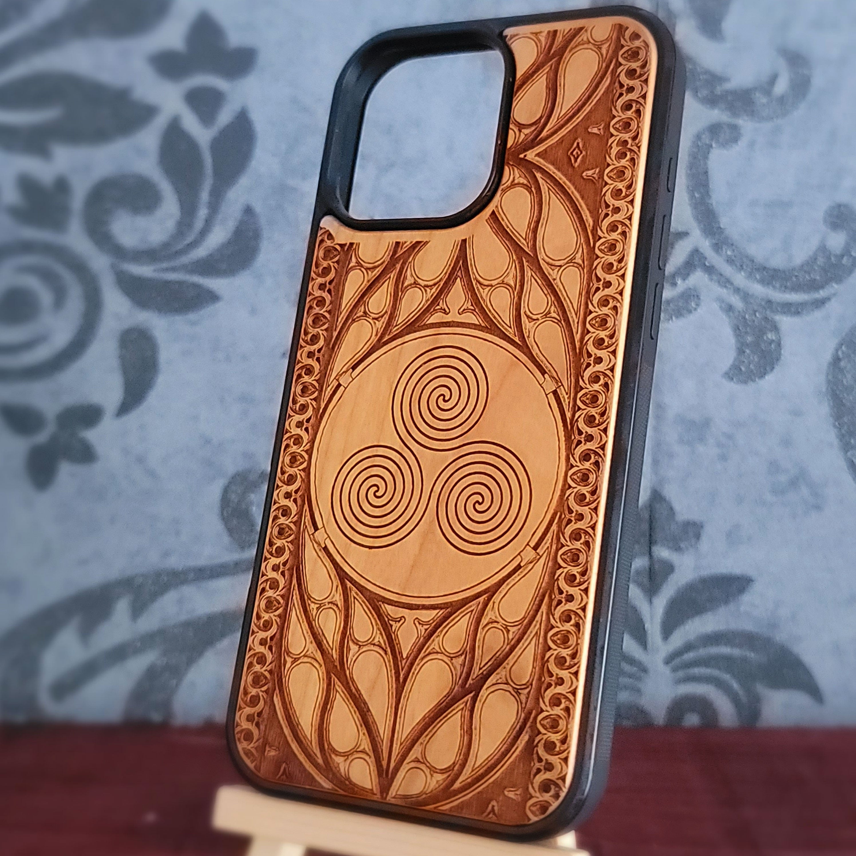 Celtic Spiral engraved wood phone case for iPhone and Galaxy with triskelion symbol in gothic wood frame.
