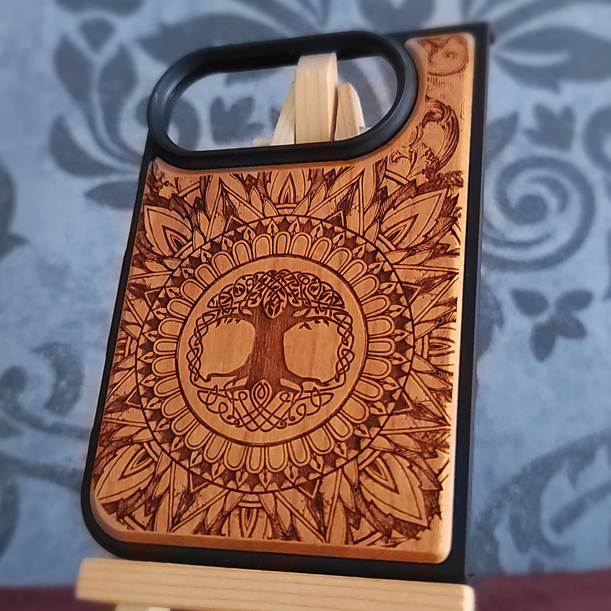 Close up of Celtic Tree of Life artwork deeply engraved into natural cherrywood phone case