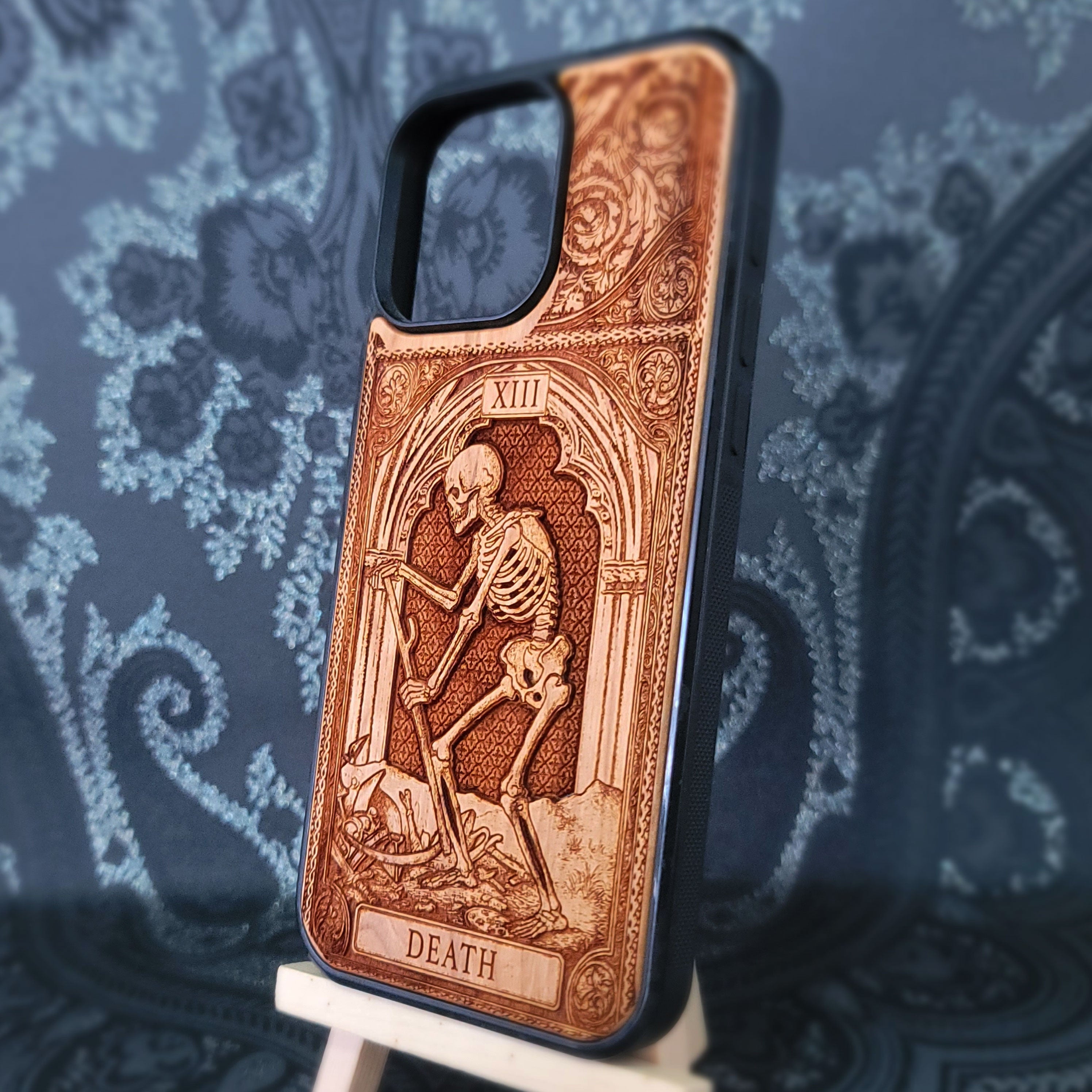 Deep laser engraved wooden phone case featuring the Death tarot card with gothic mystical details on natural wood for iPhone and Samsung Galaxy models.