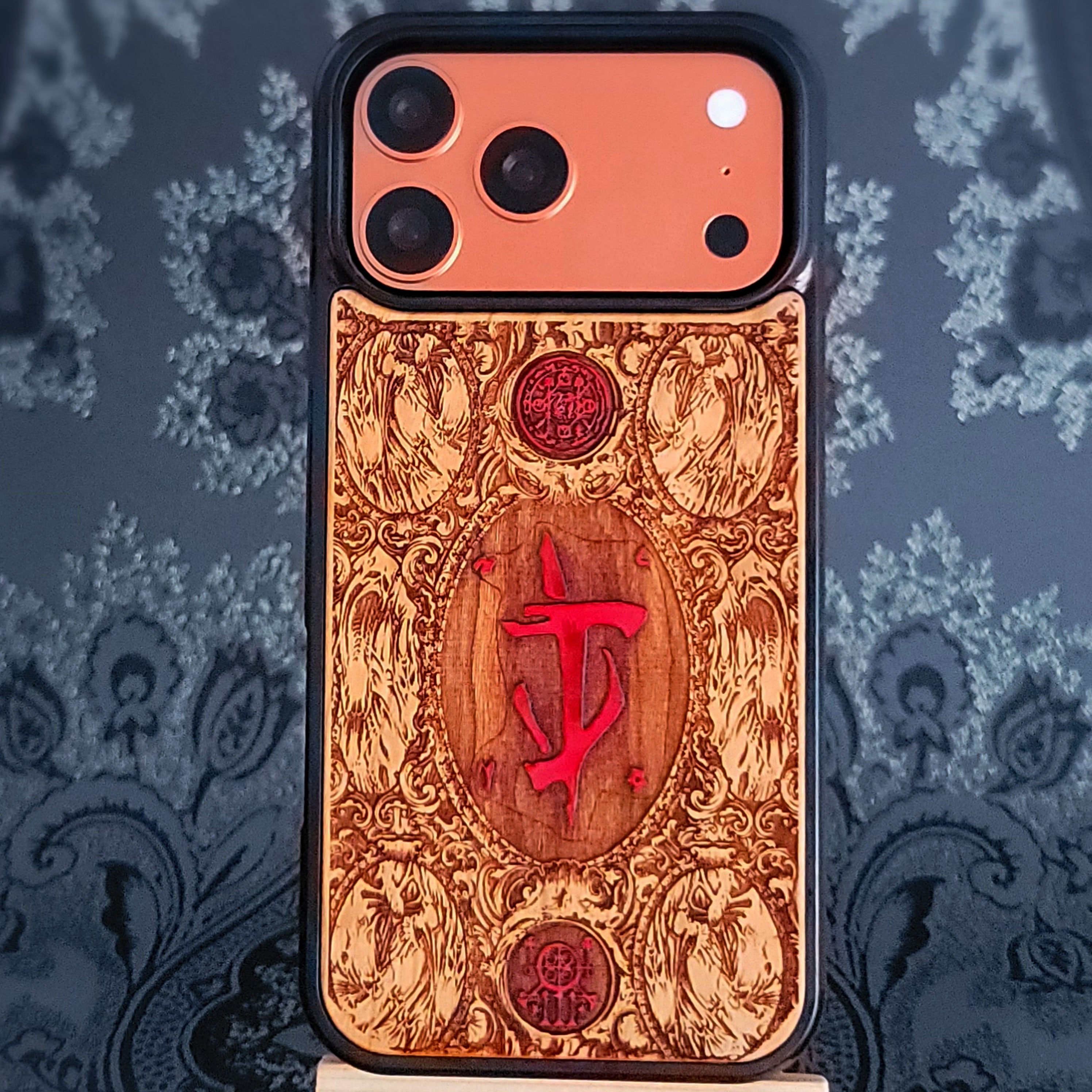 Phone case with intricate design and red doom symbol on a decorative background