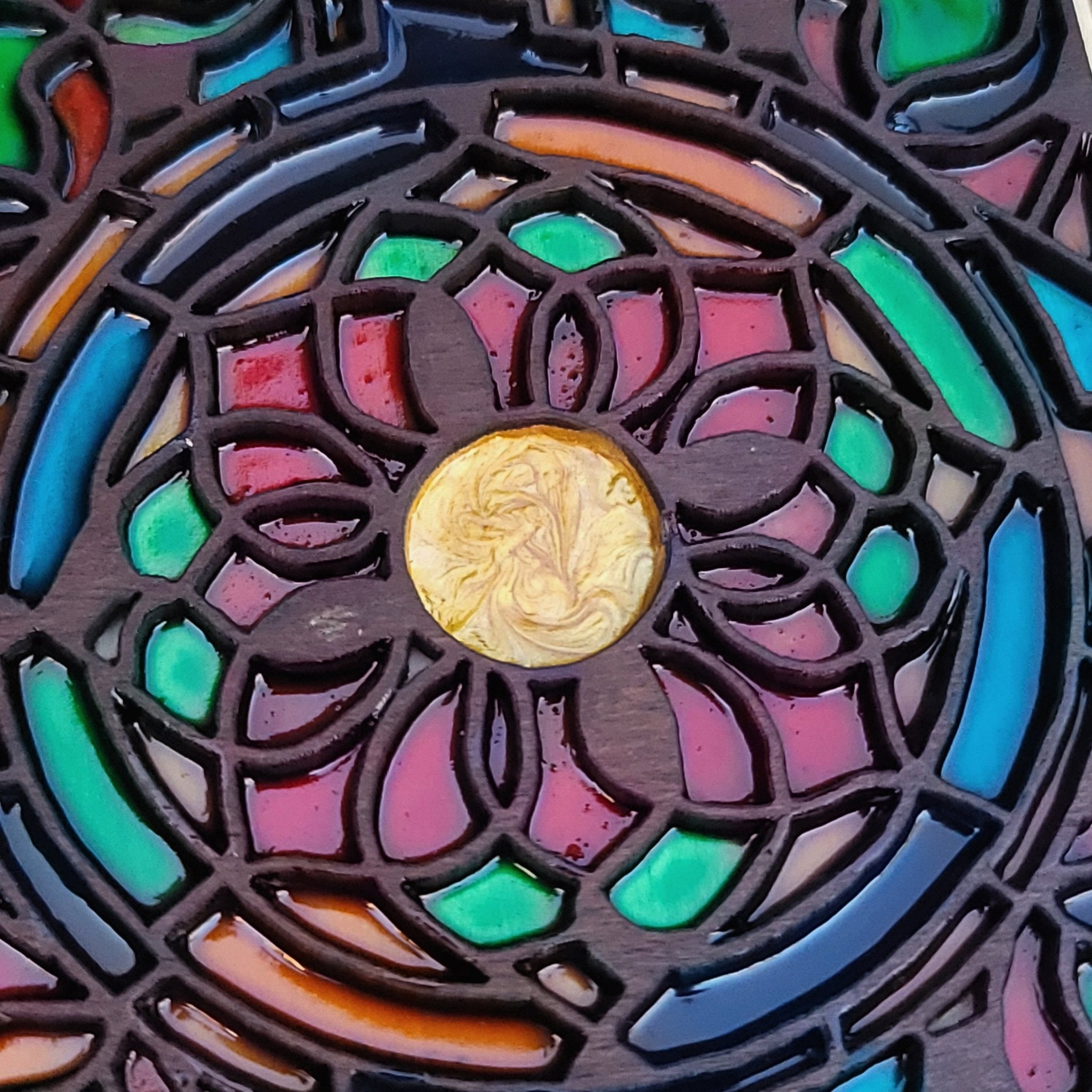 Stained glass effect flower engraving on gothic window-shaped wood panel.