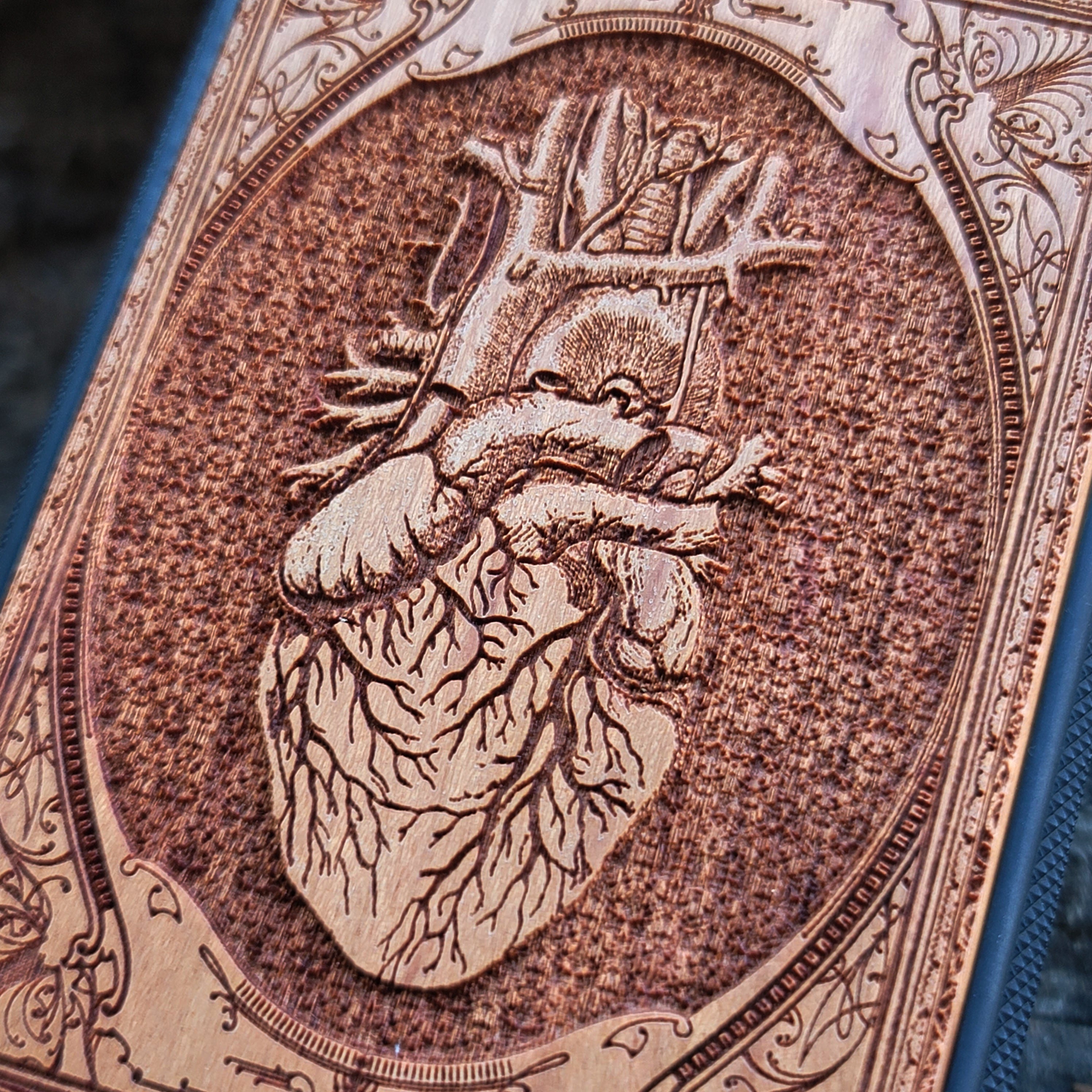 Gothic wooden phone case featuring an anatomical human heart design, intricately engraved. Compatible with iPhone , iPhone 15, Galaxy S, Note 20, and other models. Ideal for fans of gothic and anatomical art.