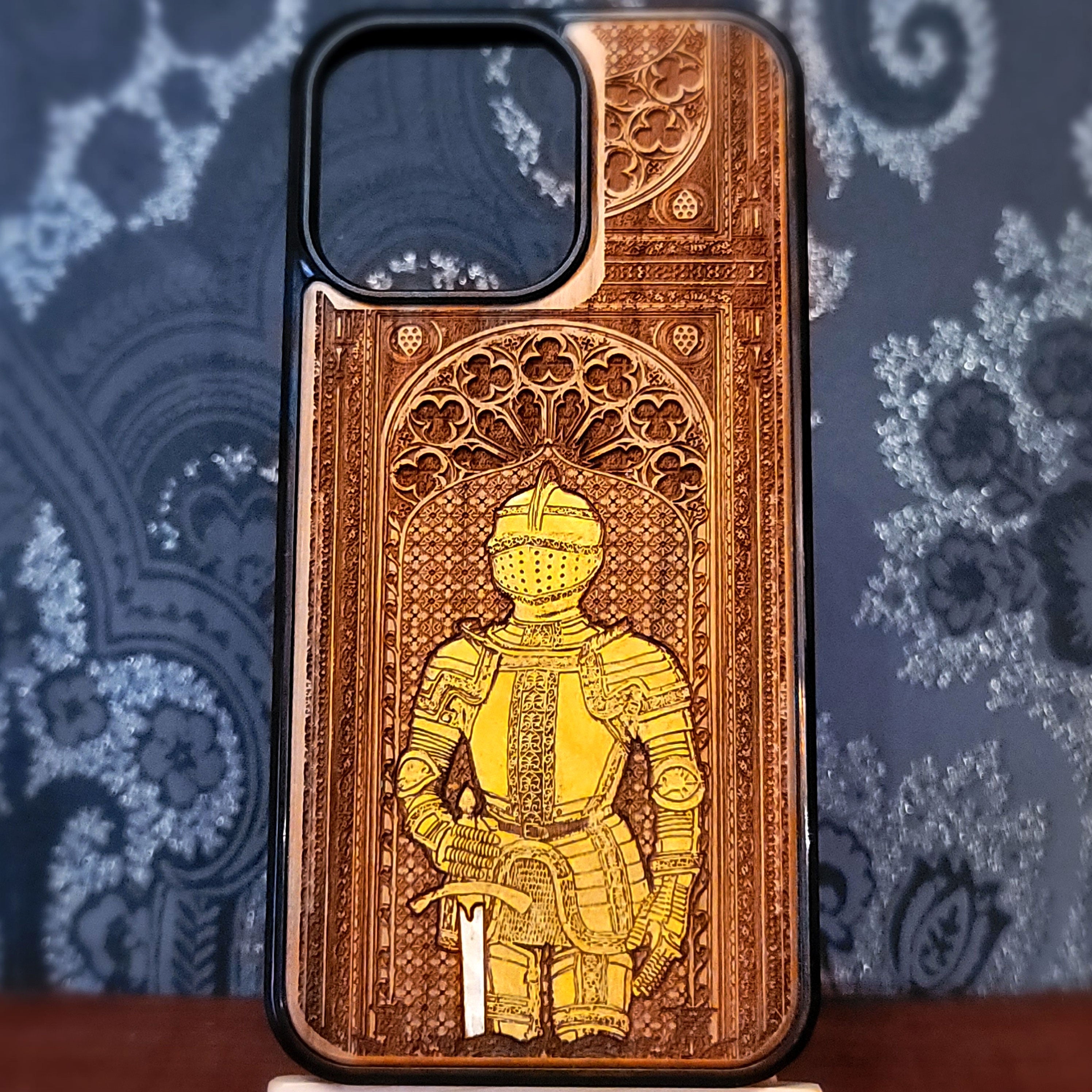 Deep laser engraved wooden phone case featuring a medieval knight in detailed armor holding a sword on natural wood for iPhone and Samsung Galaxy models.
