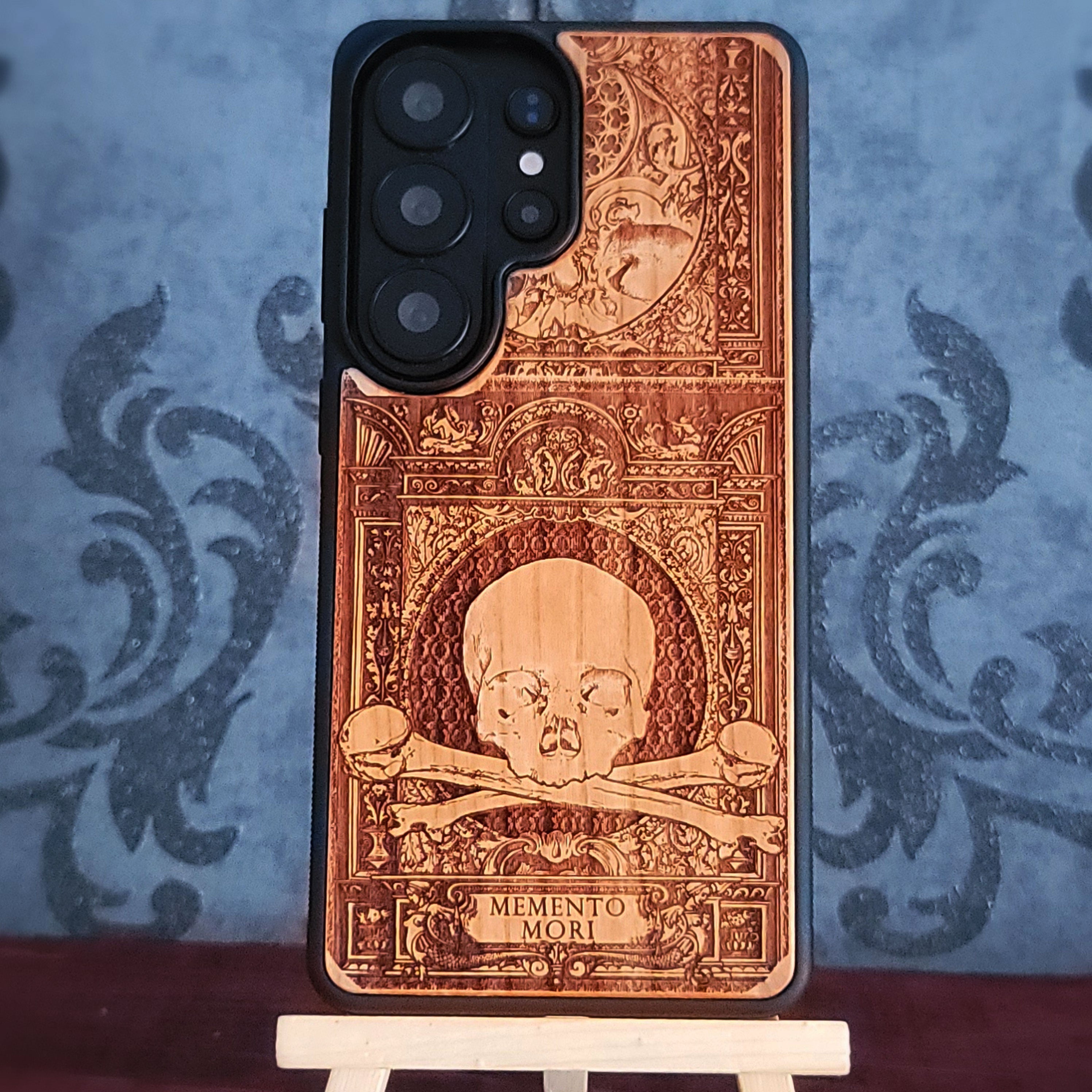 Laser-engraved Memento Mori wood phone case for iPhone and Galaxy – skull and hourglass symbolism, dark art design.