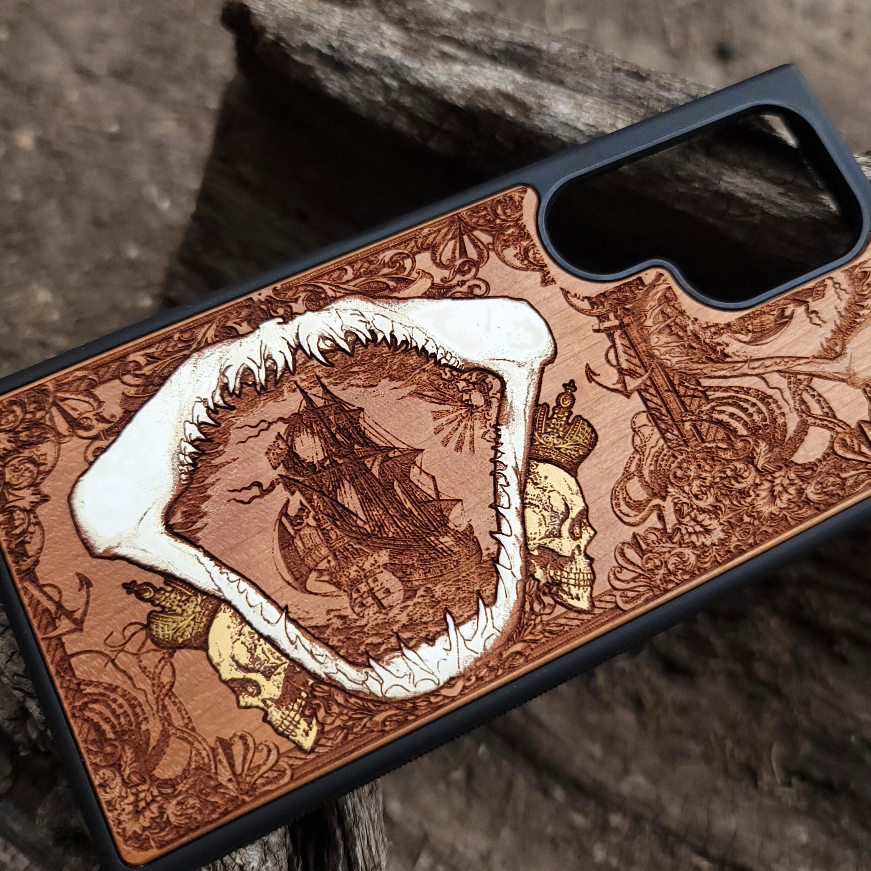 Close-up of handcrafted cherry wood phone case featuring a detailed shark engraving.