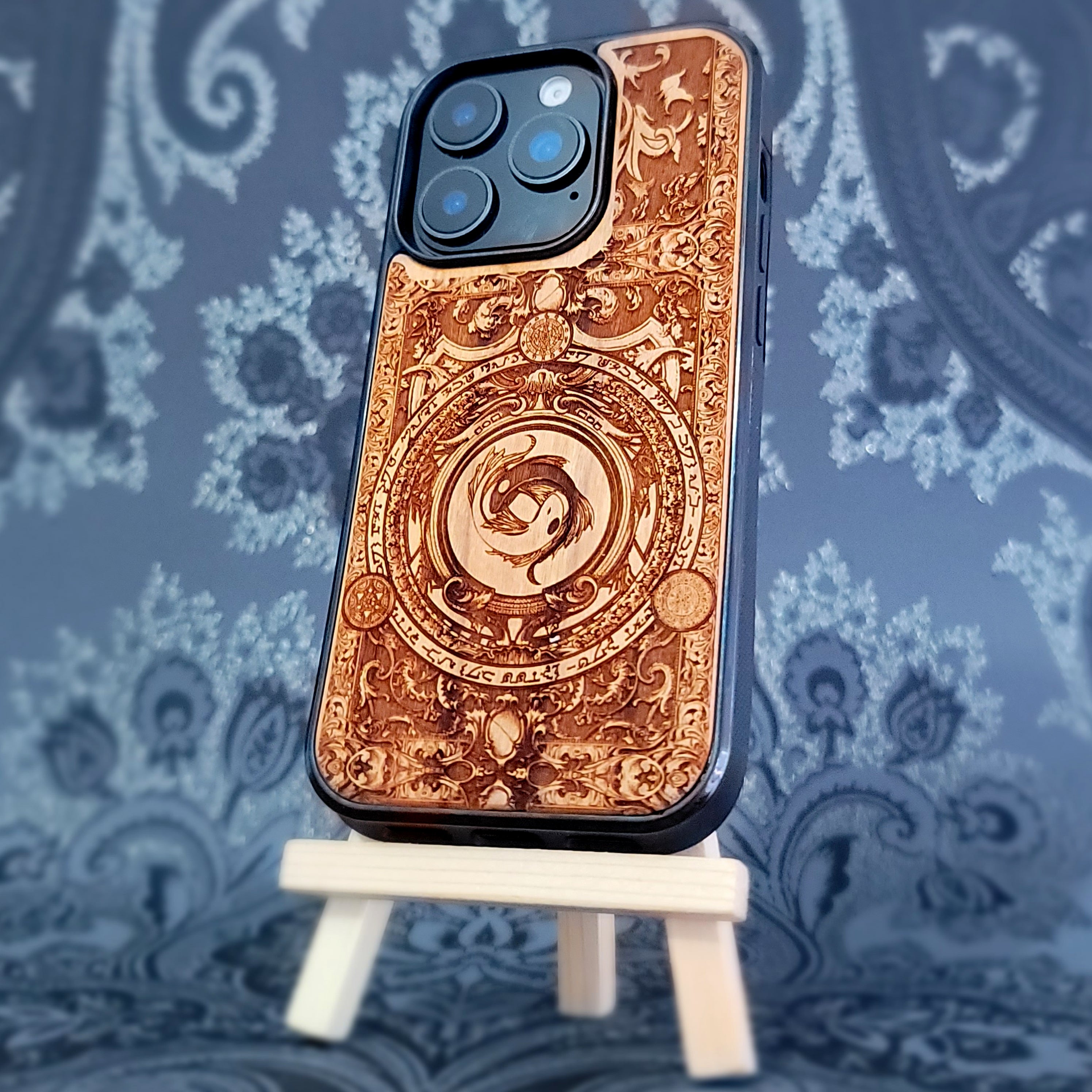 Deep laser engraved wooden phone case featuring two koi fish forming a yin yang symbol on natural wood for iPhone and Samsung Galaxy models.