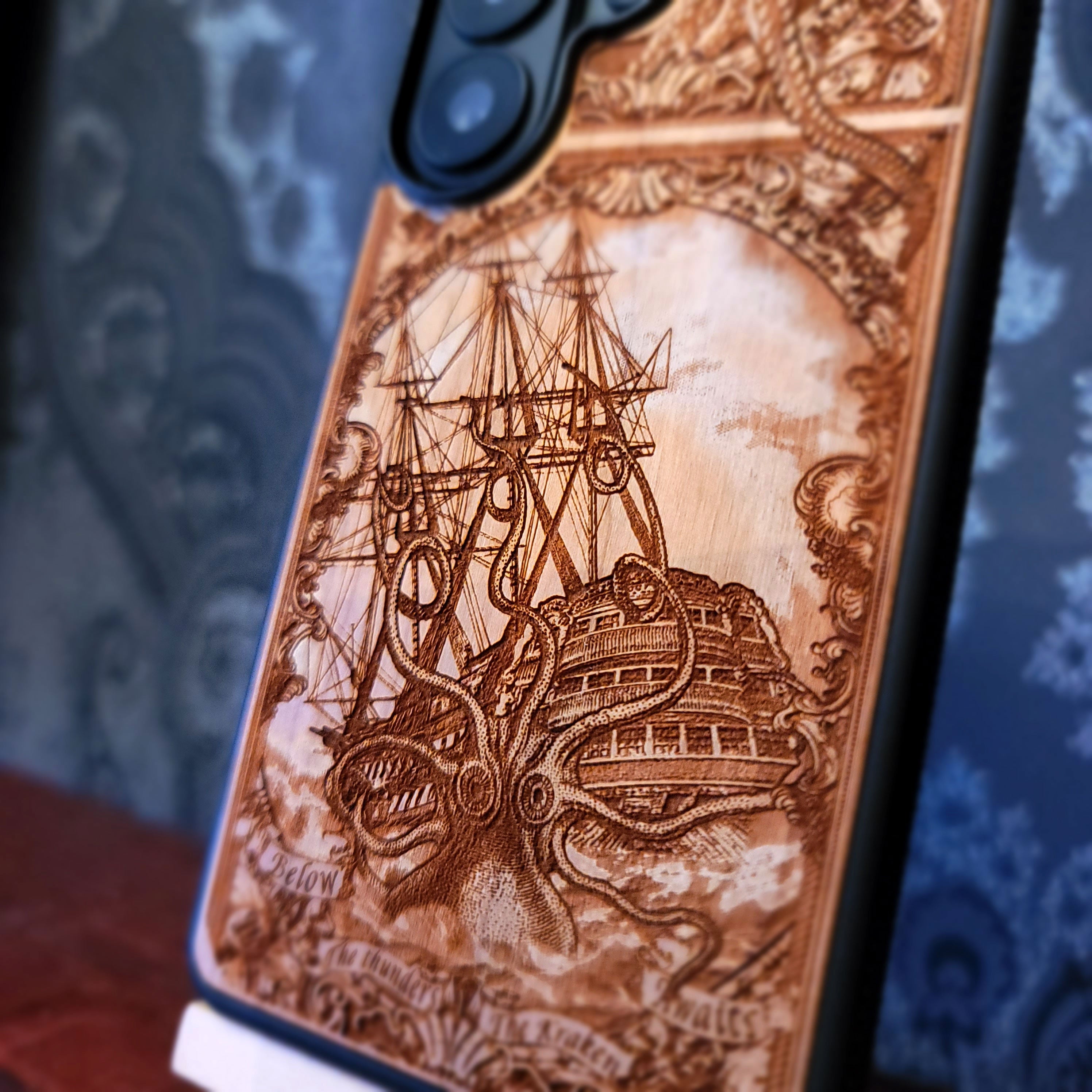 Laser engraved and hand painted wooden phone case featuring a giant Kraken sea monster attacking a ship for iPhone and Samsung Galaxy models.
