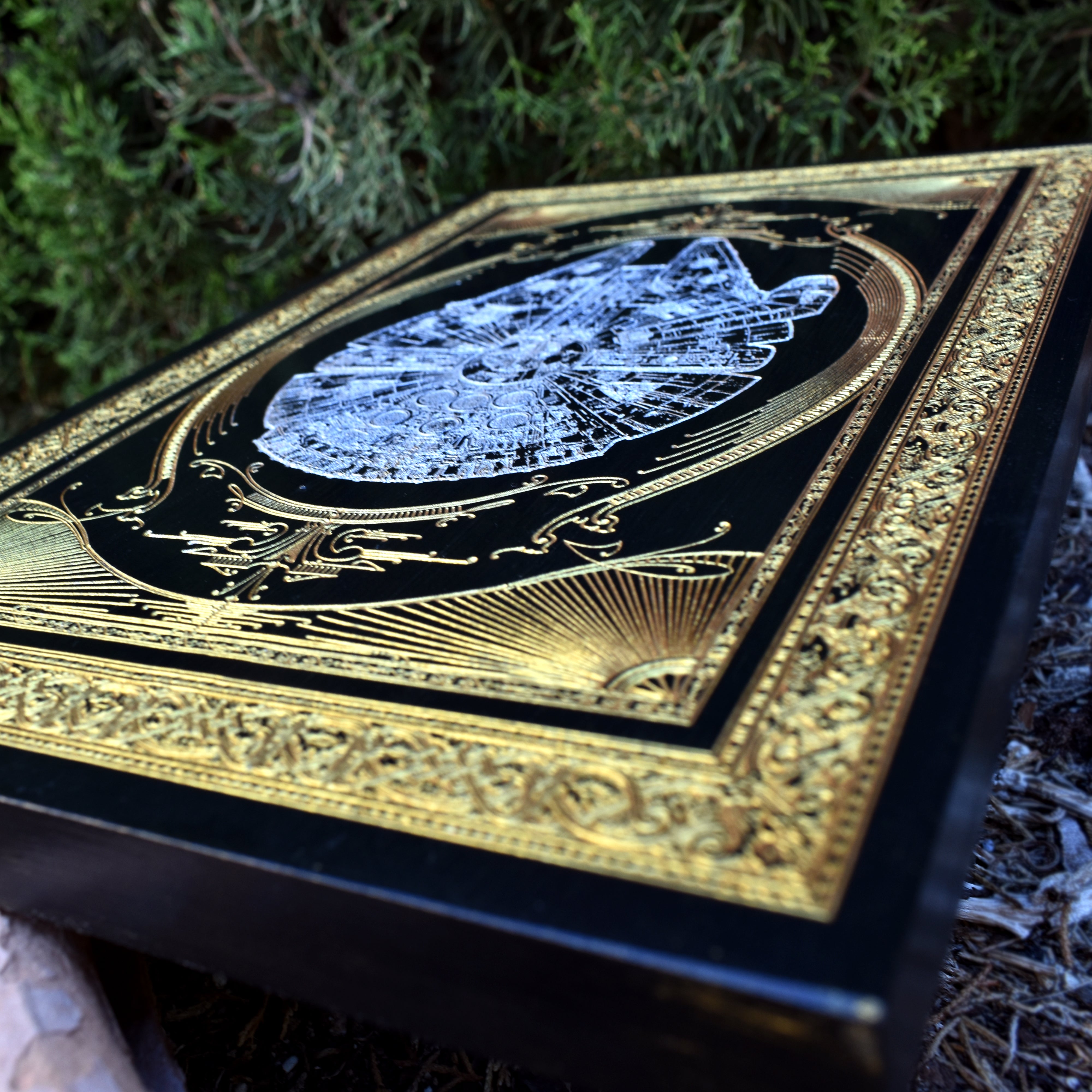 Detailed laser engraving of Millennium Falcon on natural wood plaque.