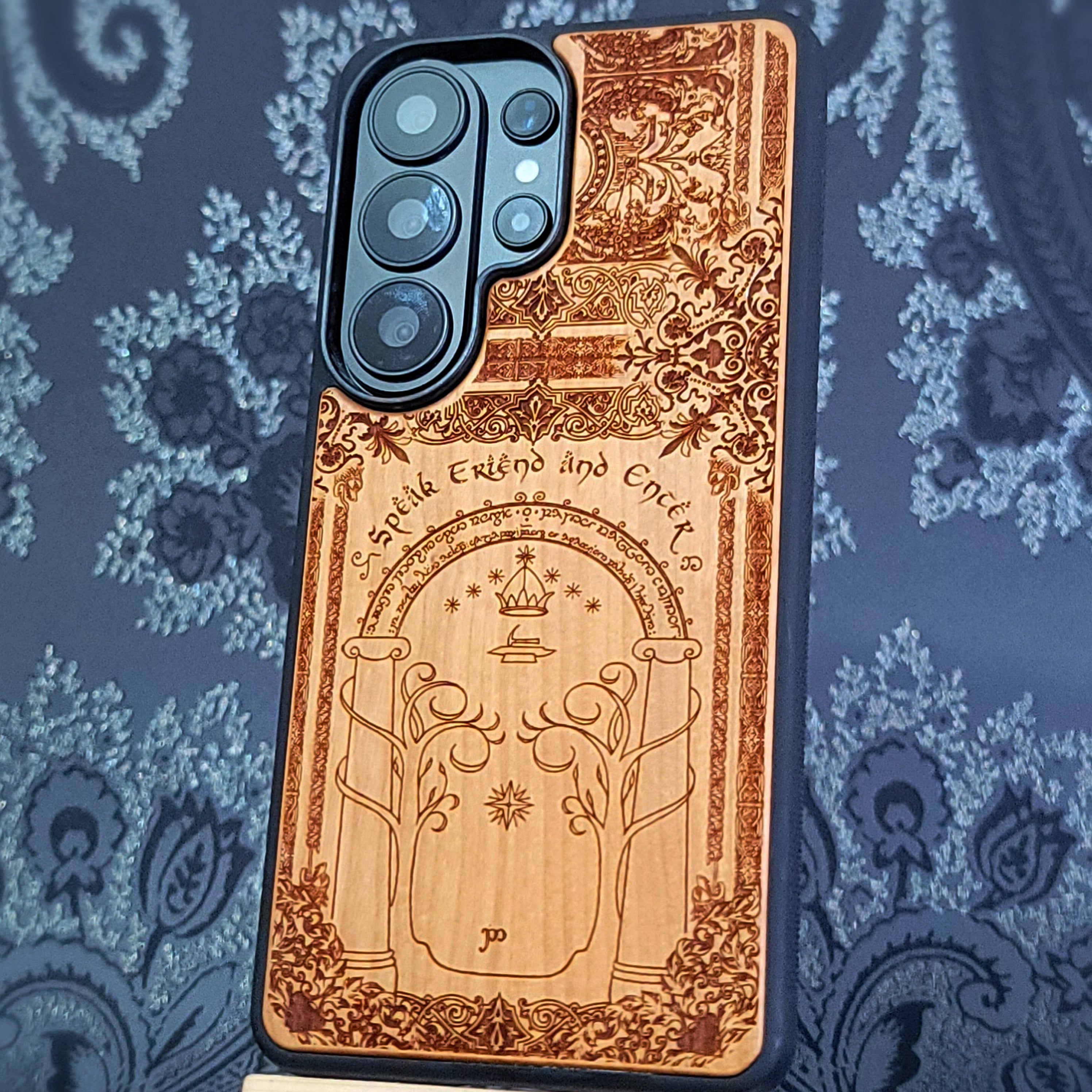 Deep laser engraved wooden phone case featuring a fantasy gate inspired by the Gates of Moria on natural wood for iPhone and Samsung Galaxy models.