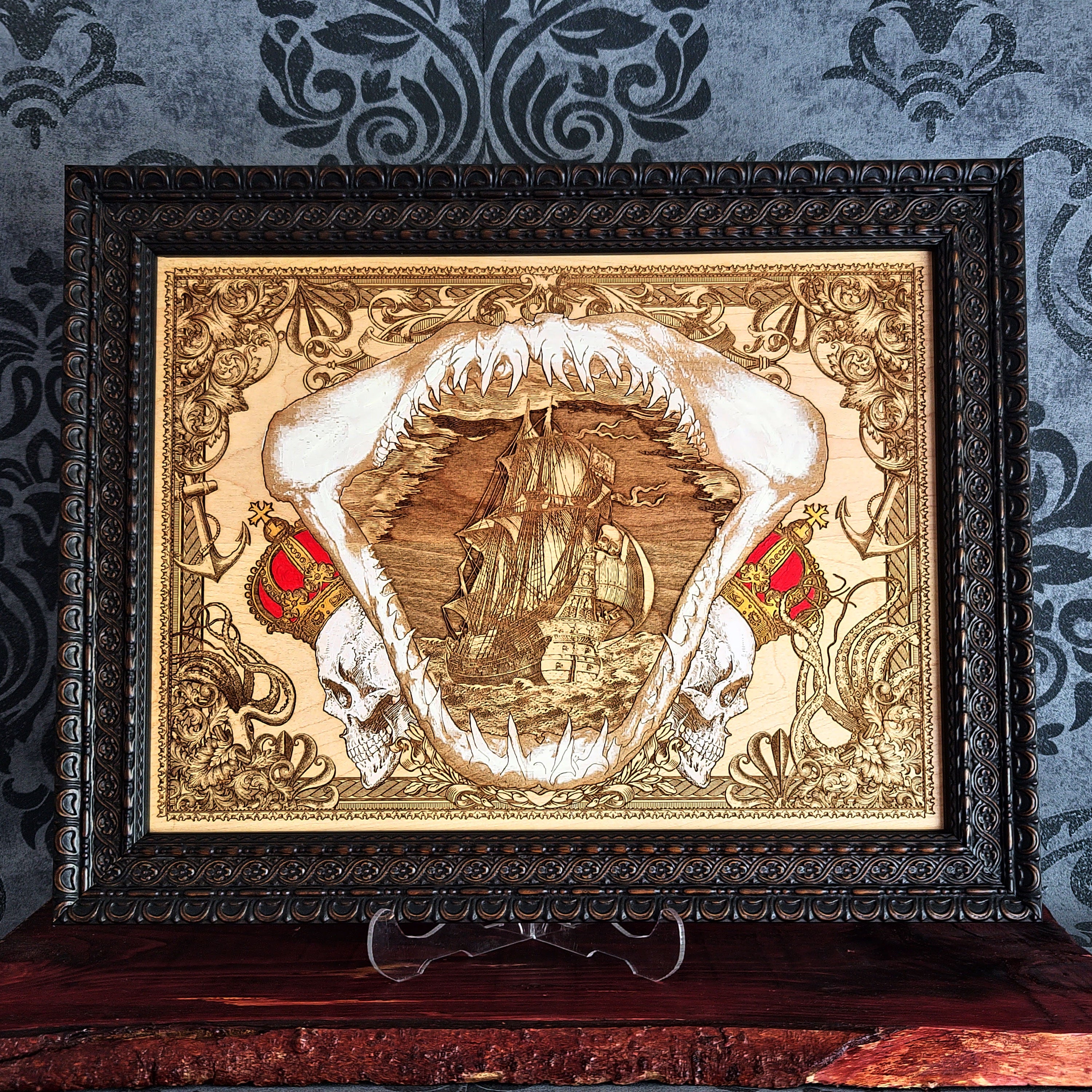 Large shark jaw and sailing ship wood wall art, dark brown ornate frame displayed around the nautical artwork