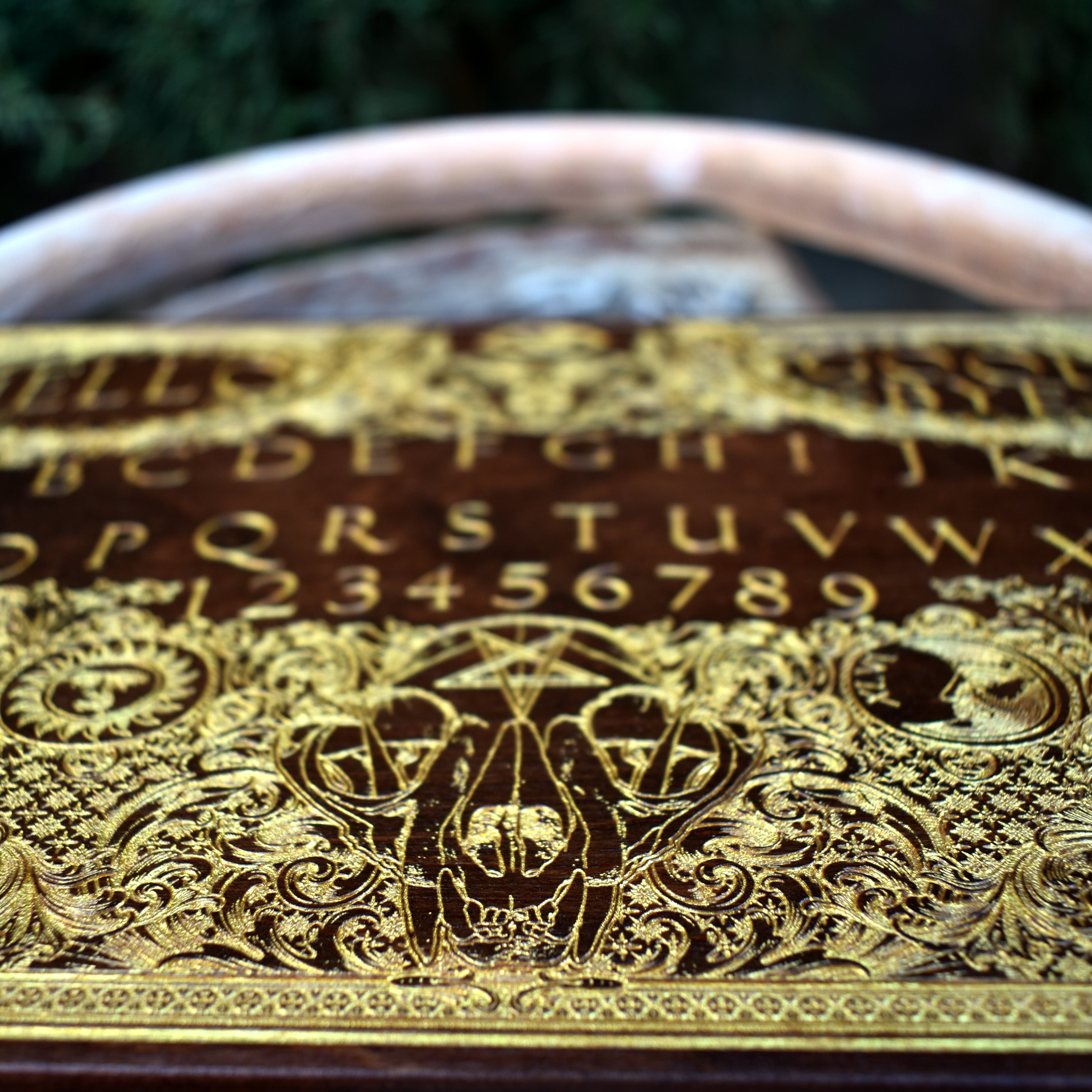Laser-engraved wood Ouija board for gothic, spiritual, or Halloween displays.