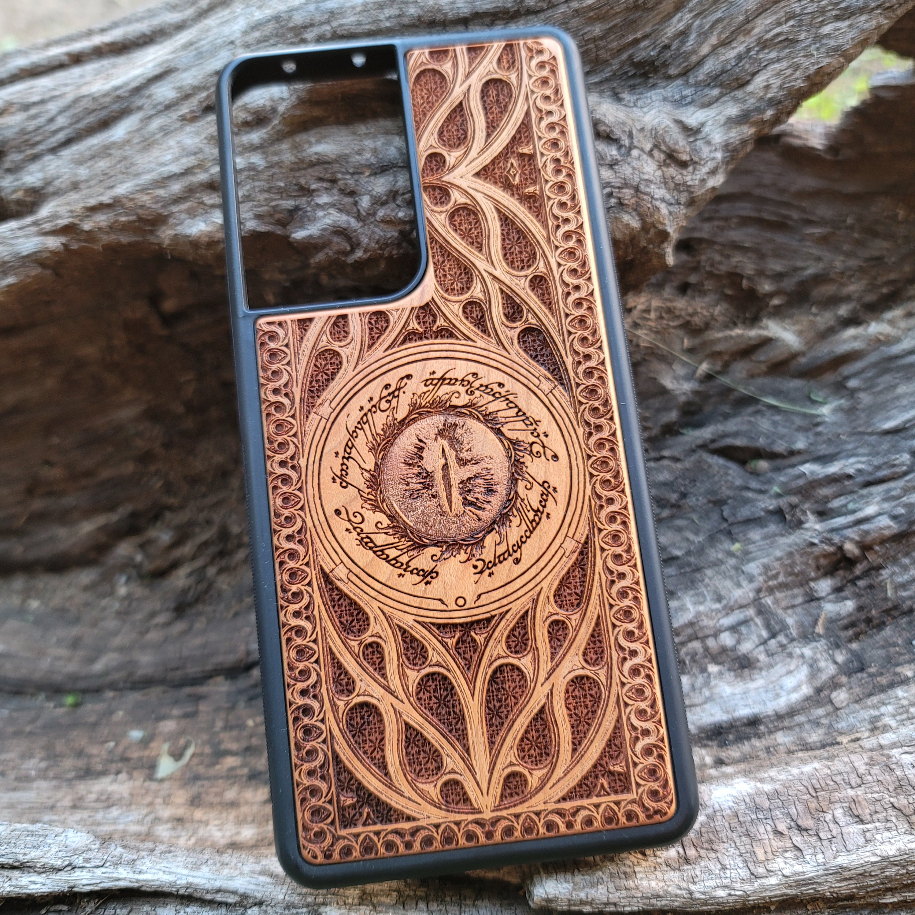Lord of the Rings wood phone case featuring the Eye of Sauron surrounded by Elvish script and intricate detailing. Laser-engraved for a unique and durable design, this case is compatible with iPhone , 15, 14, 13, 12, 11, Pro Max, Mini, and Samsung Galaxy S, S24, S23, S22, S21, S20 Ultra, Plus, Note 20. A stylish and protective accessory for Tolkien fans.