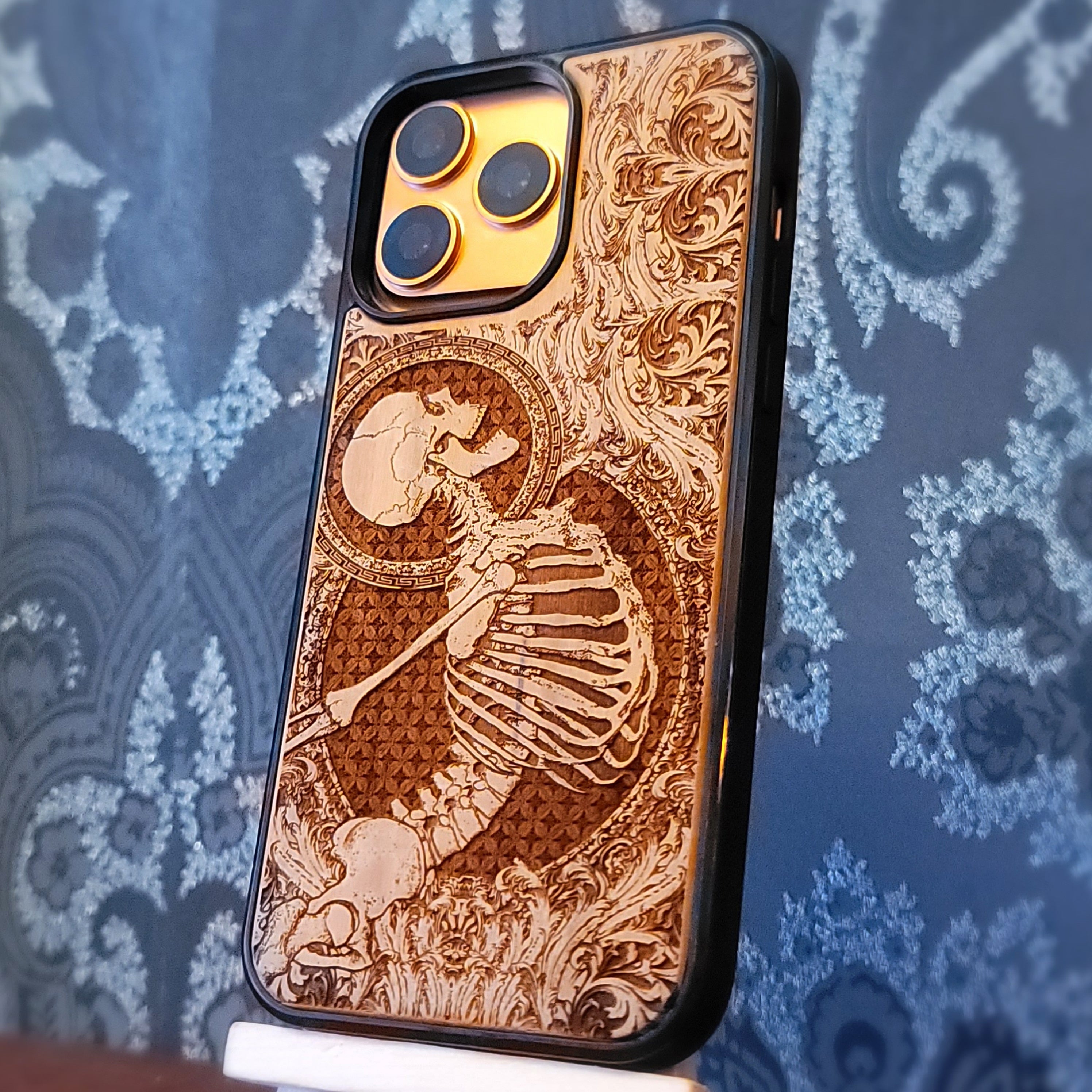 Deep laser engraved wooden phone case featuring a happy skeleton design on natural wood for iPhone and Samsung Galaxy models.
