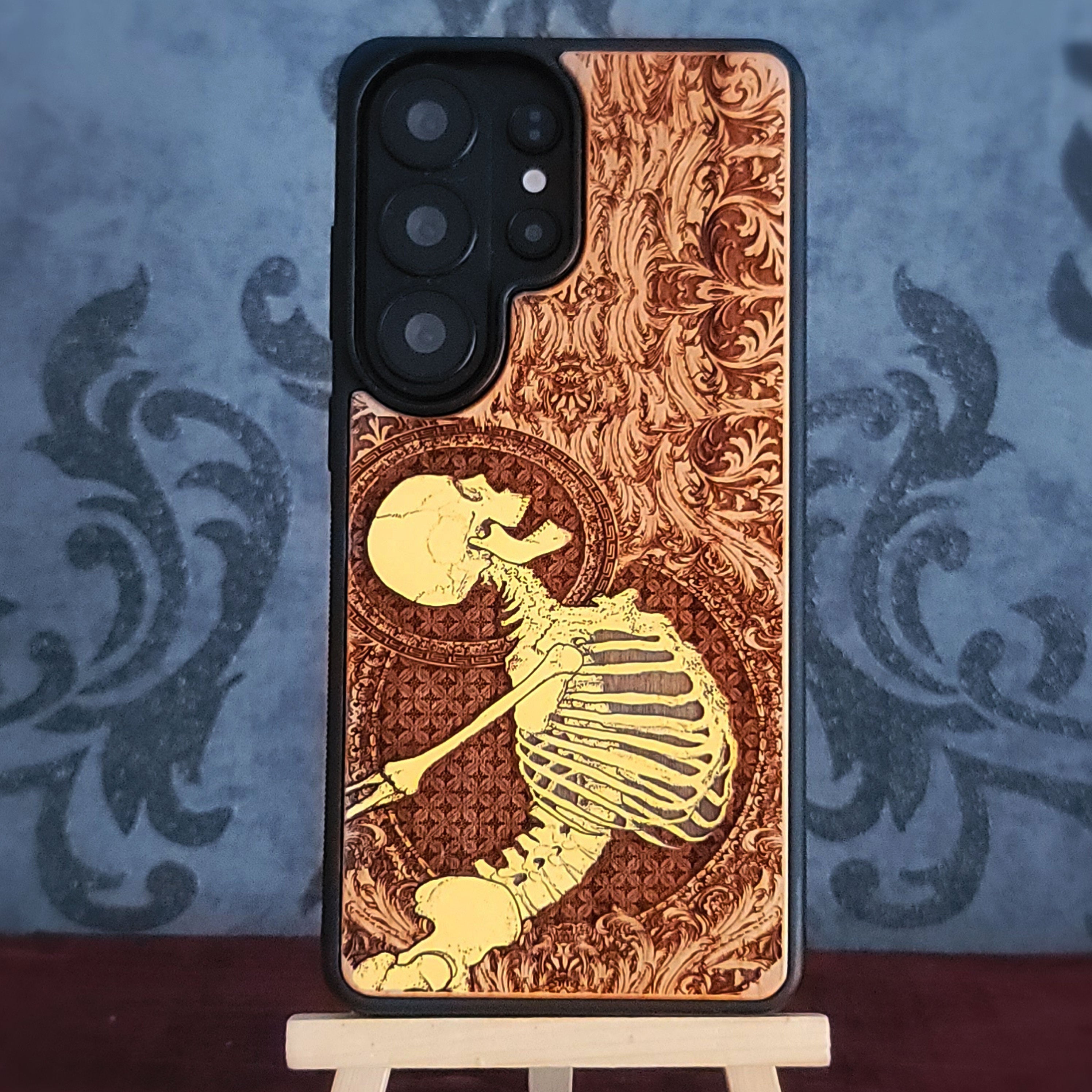 Cherry wood phone case with laser-engraved Gothic skeleton design for iPhone & Samsung Galaxy.