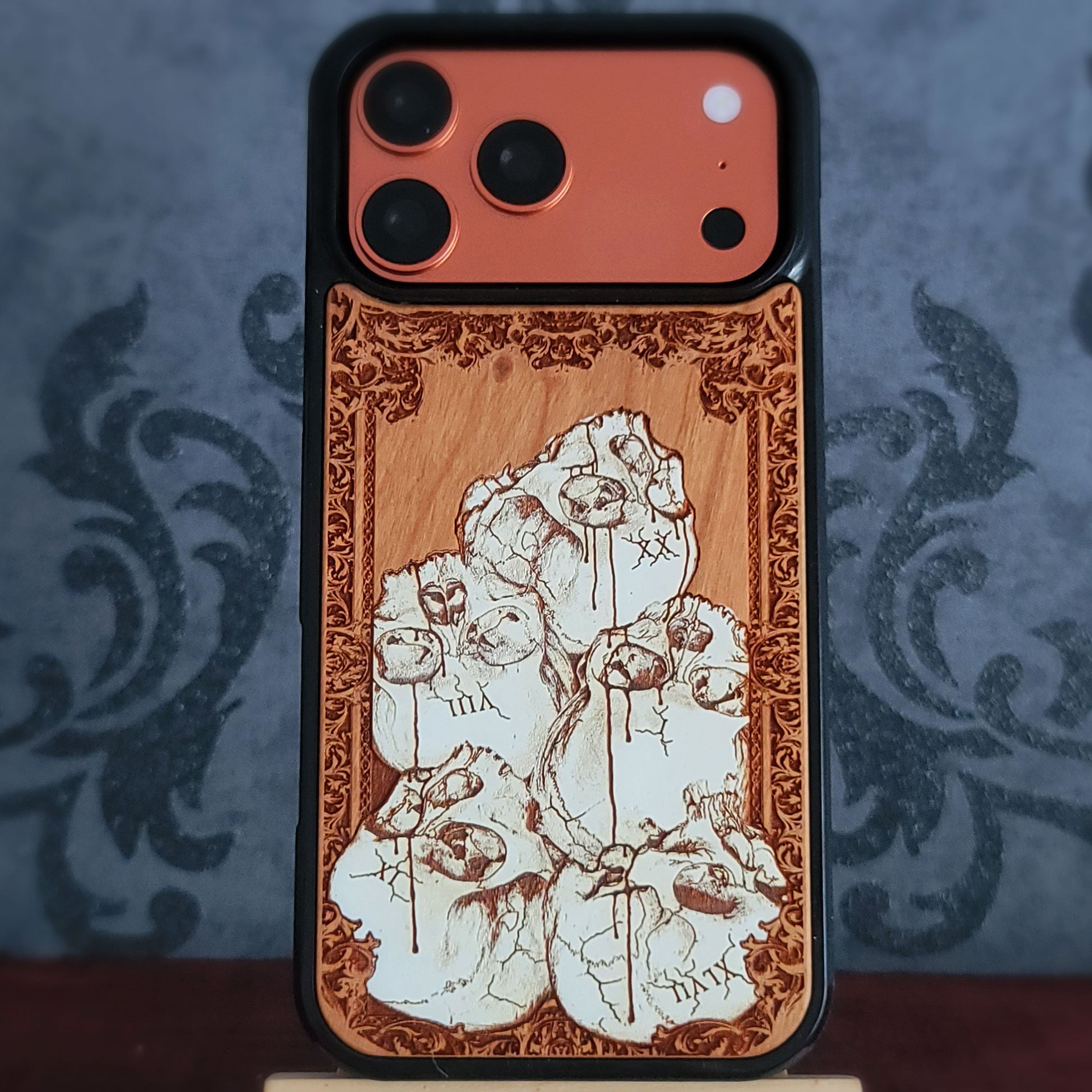 Hand-painted gothic wood phone case with stacked skulls and dripping details, compatible with iPhone and Galaxy, dark horror design.