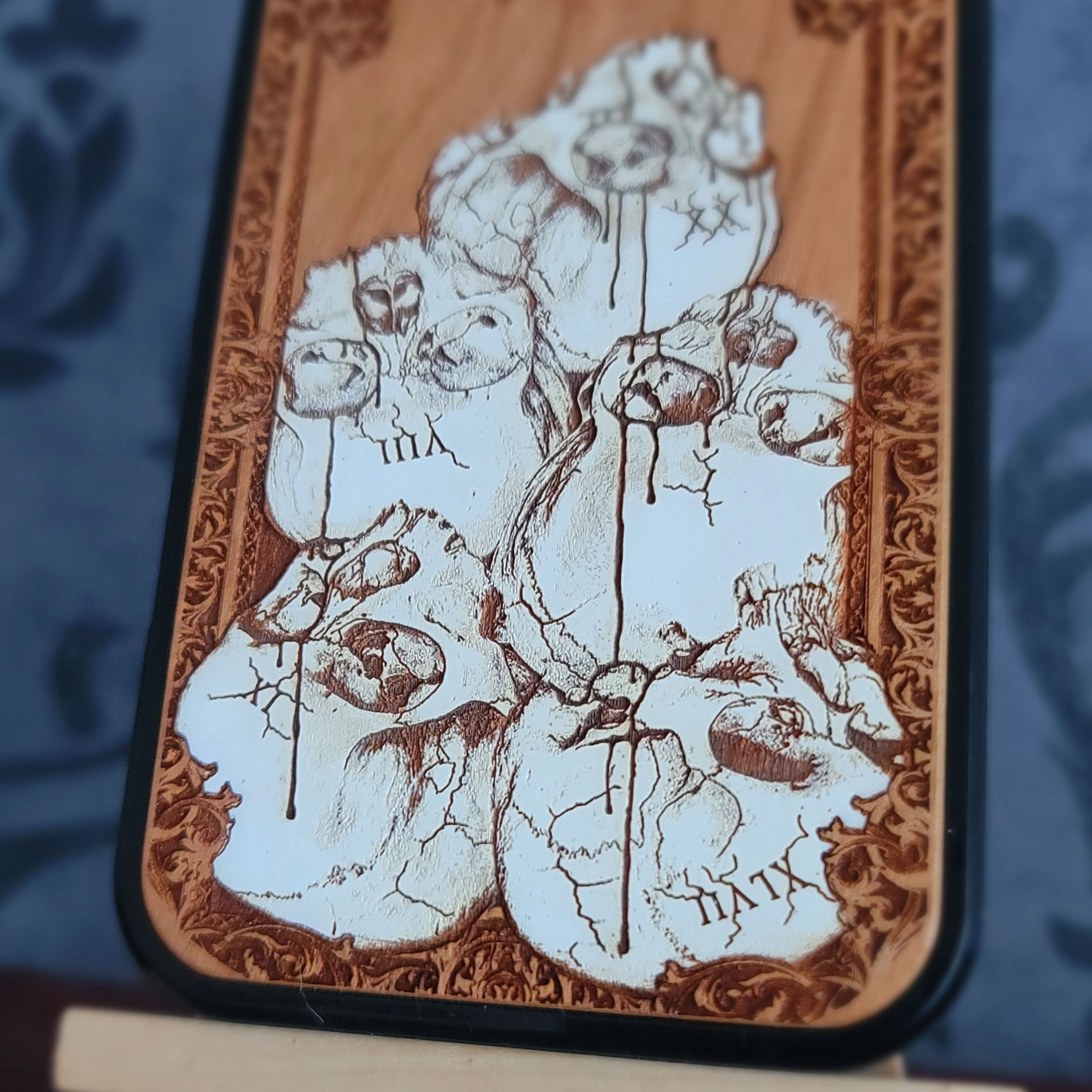 Hand-painted gothic wood phone case with stacked skulls and dripping details, compatible with iPhone and Galaxy, dark horror design.