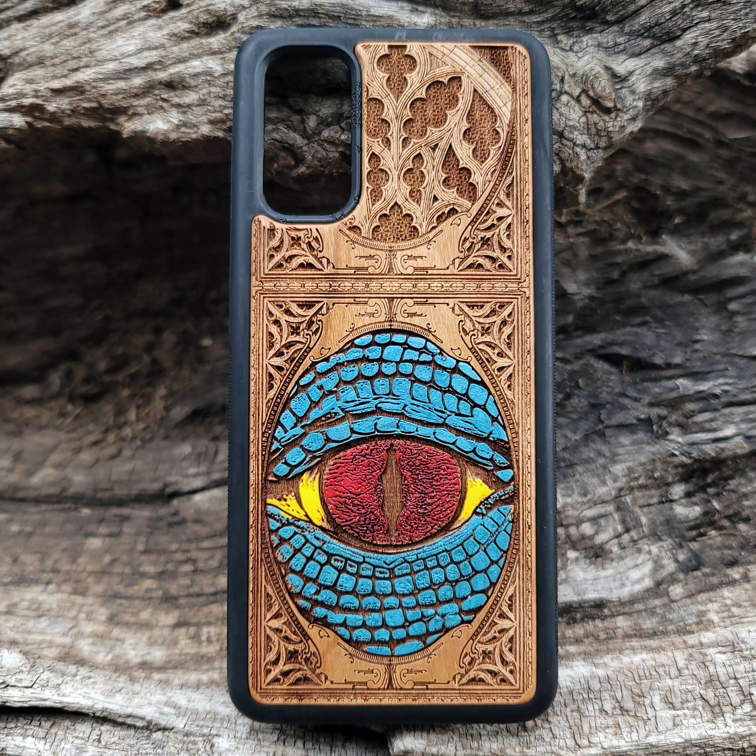 Snake eye gothic artwork engraved on a wooden phone case, compatible with iPhone and Samsung Galaxy S.