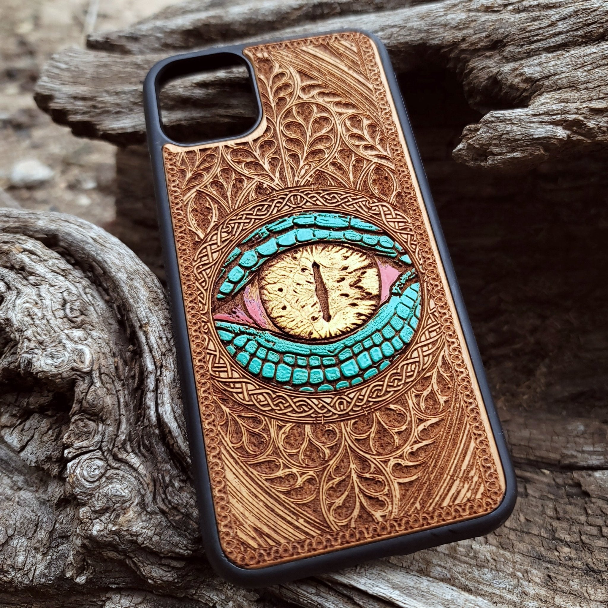 Close-up of intricate laser-engraved Snake Eye Gothic artwork on cherry wood phone case for iPhone & Samsung Galaxy