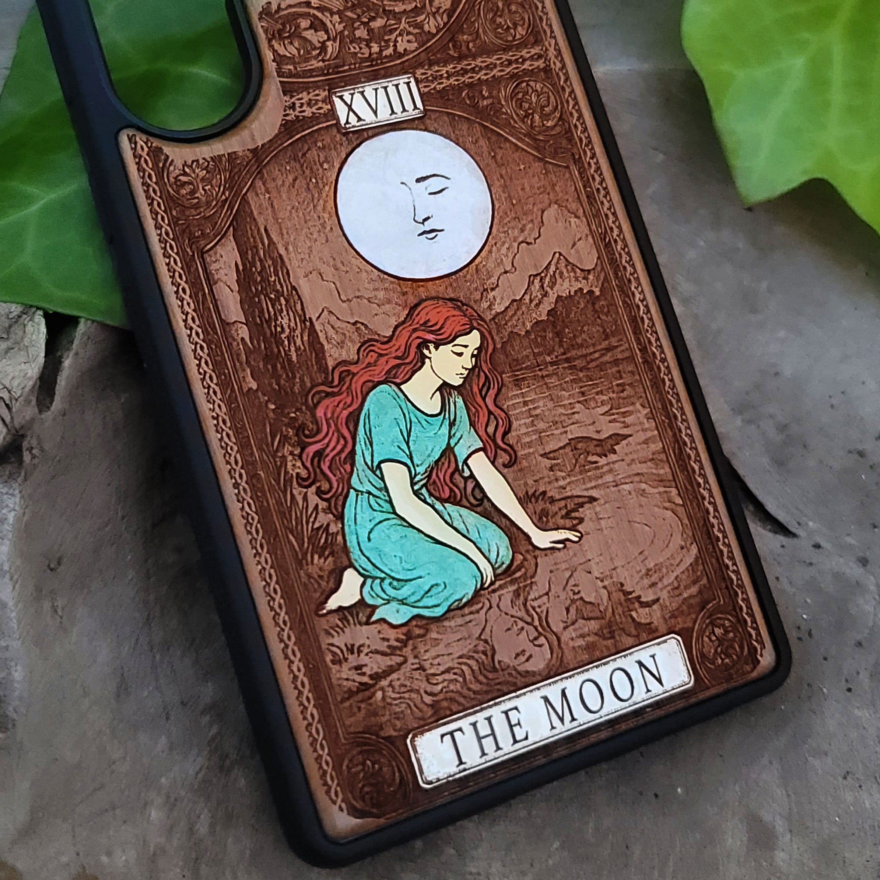 Phone case with 'The Moon' tarot card design on wood