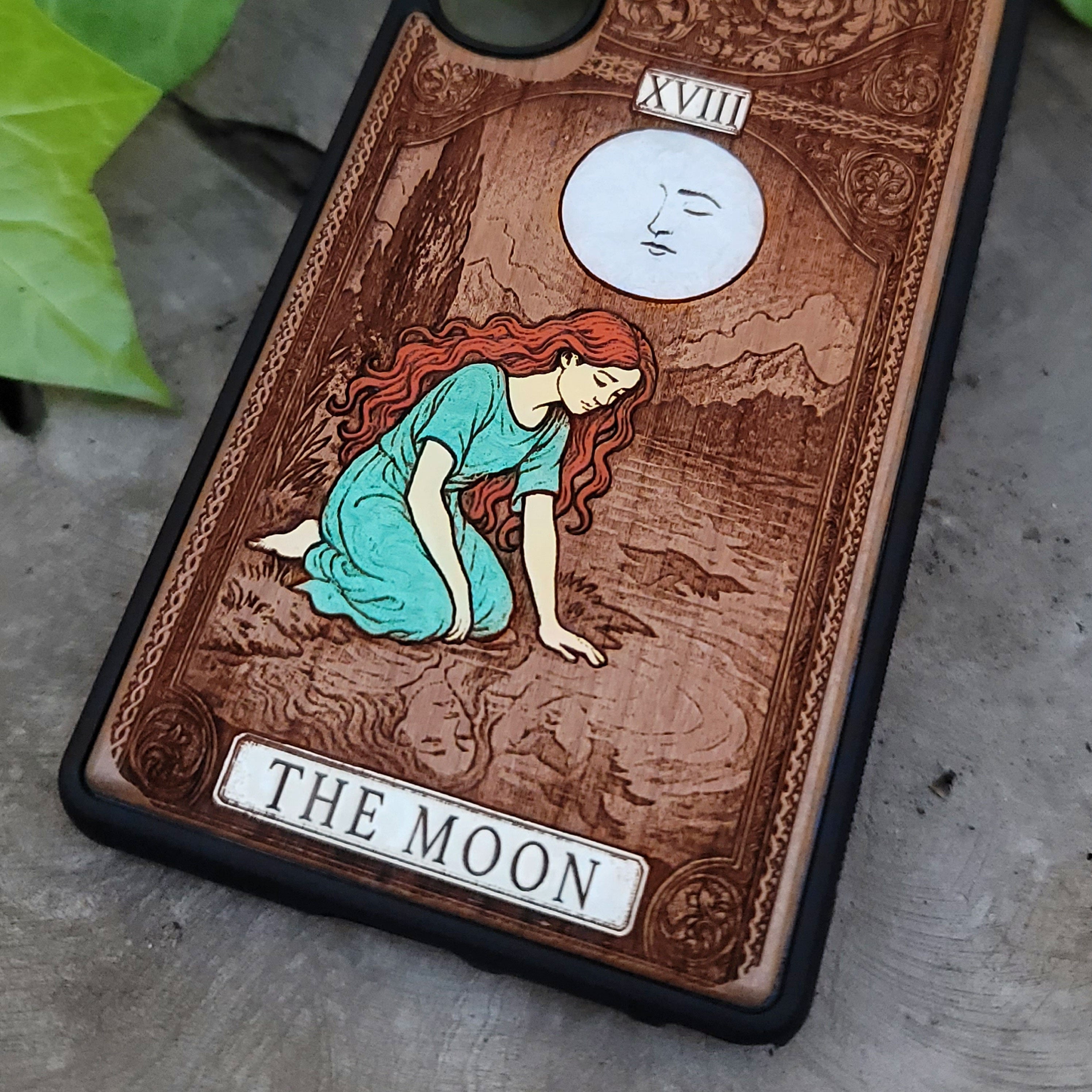 Phone case with 'The Moon' tarot card design on wood