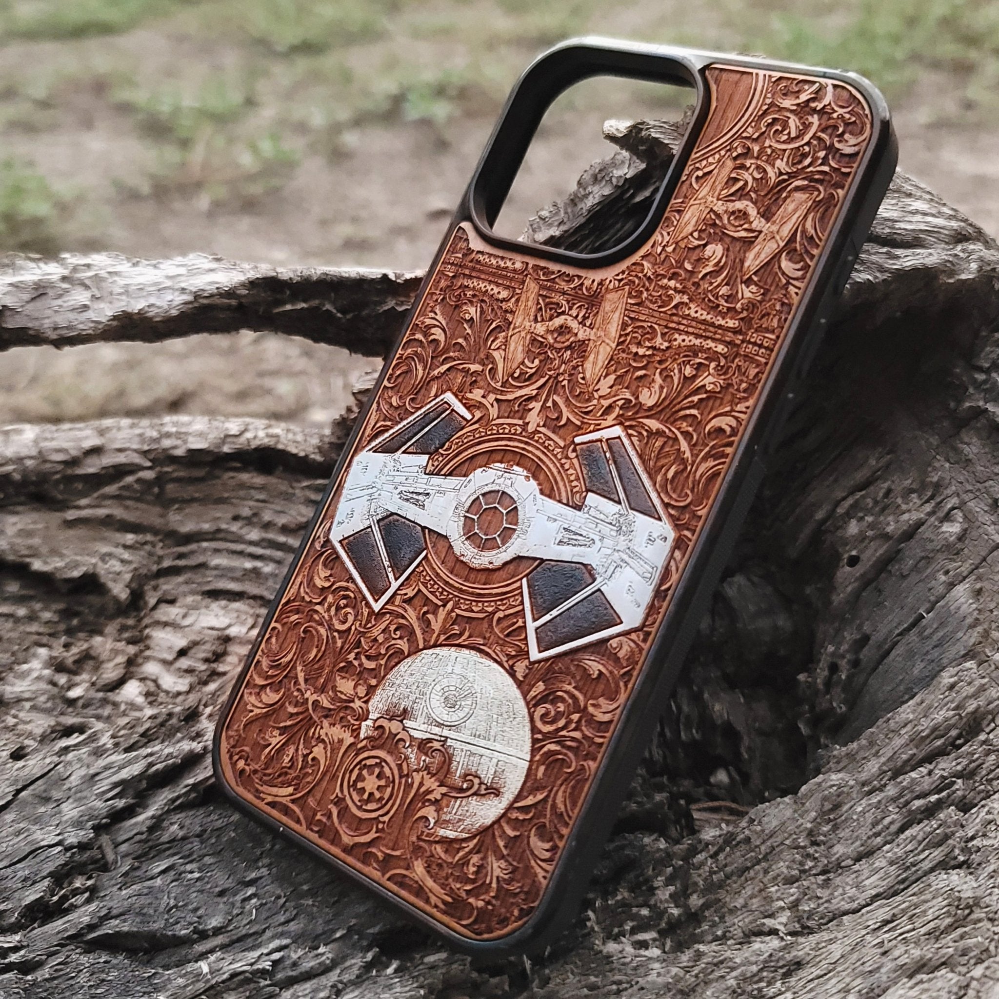 Close-up of handcrafted cherry wood phone case featuring intricate Star Wars-inspired spaceship engraving.