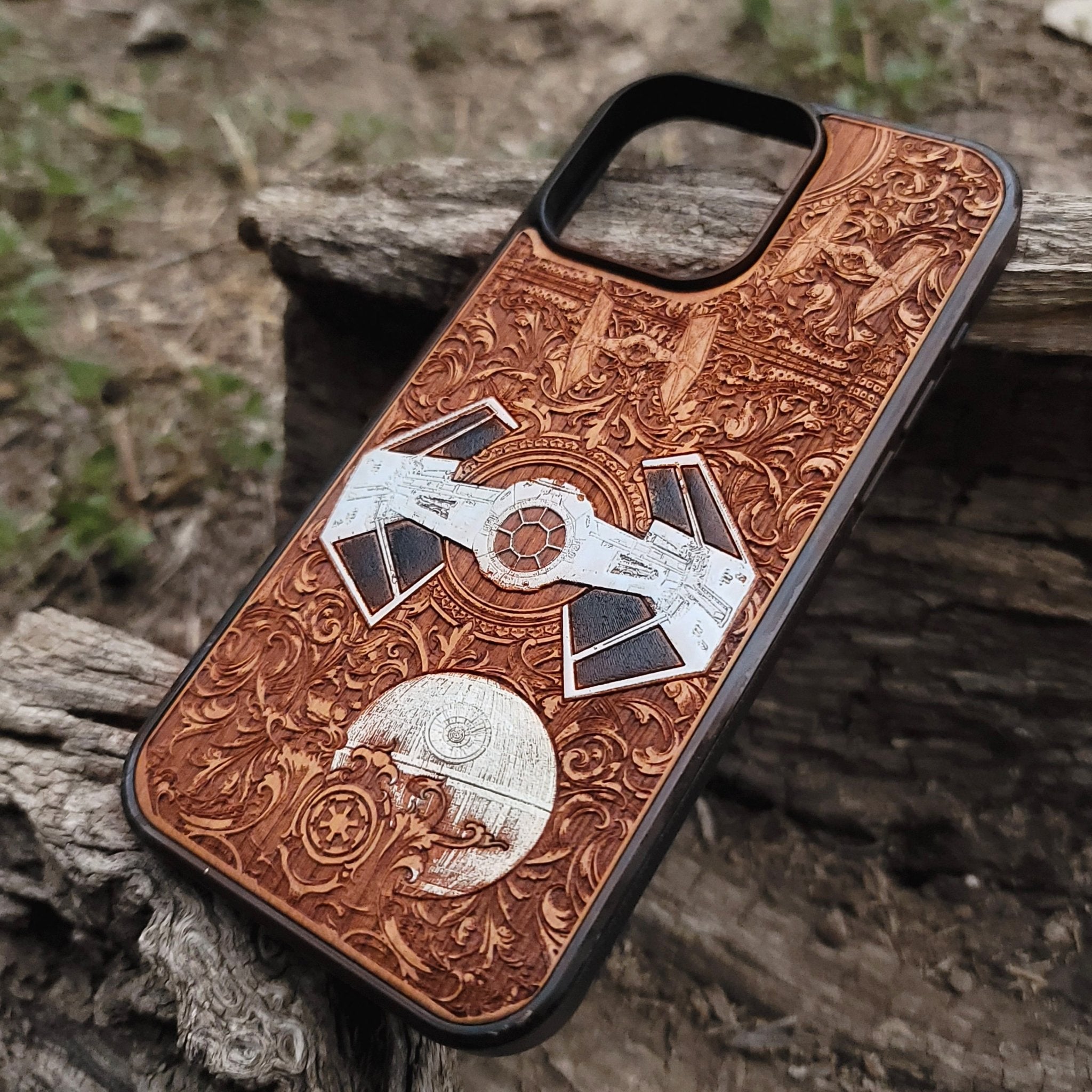 Close-up of handcrafted cherry wood phone case featuring intricate Star Wars-inspired spaceship engraving.