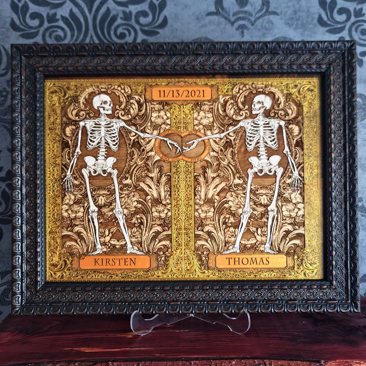 Skeleton couple wood art with ornate golden leaf frame