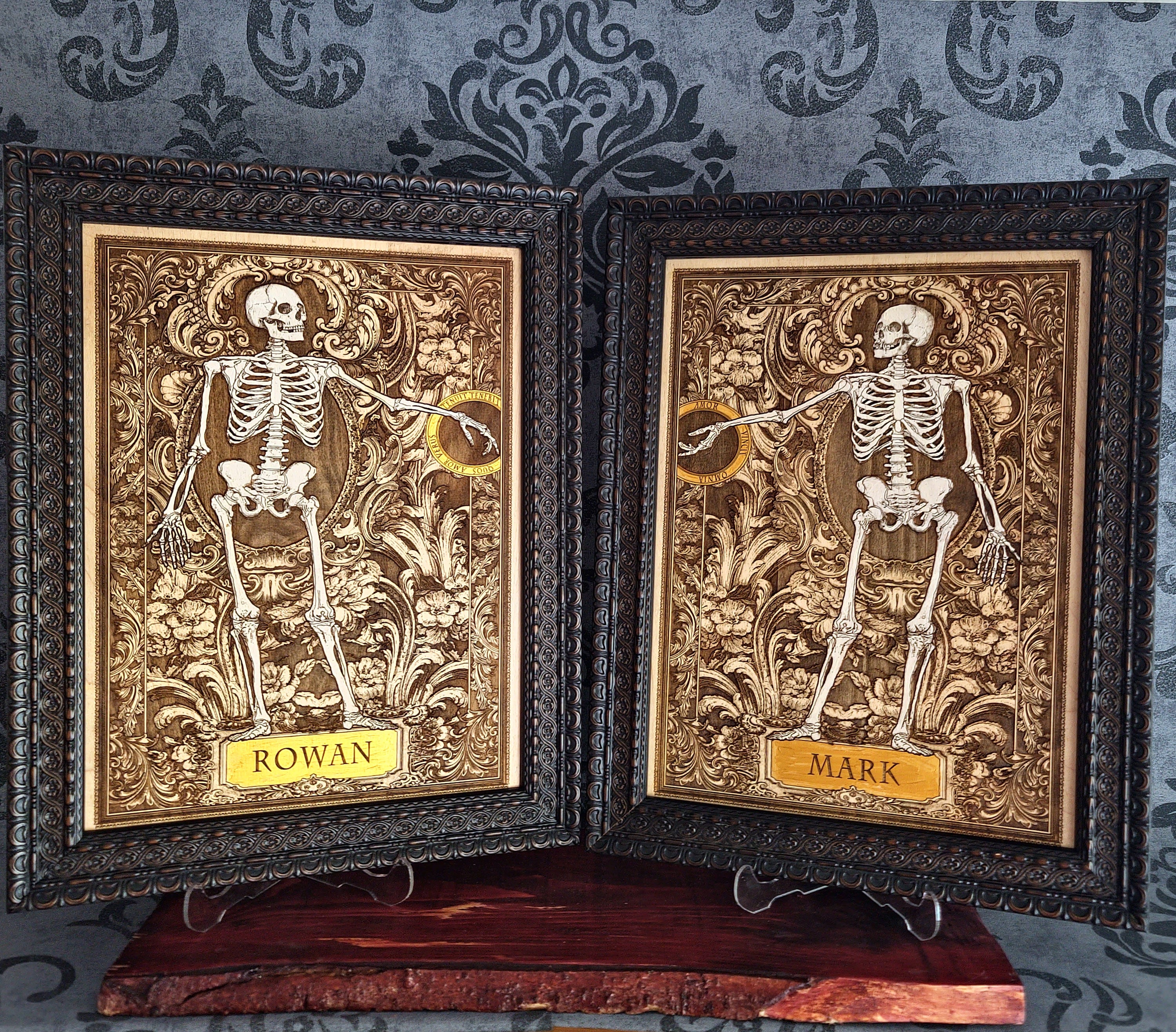 Two framed gothic-style skeleton art prints with ornate gold and black frames, displayed side-by-side