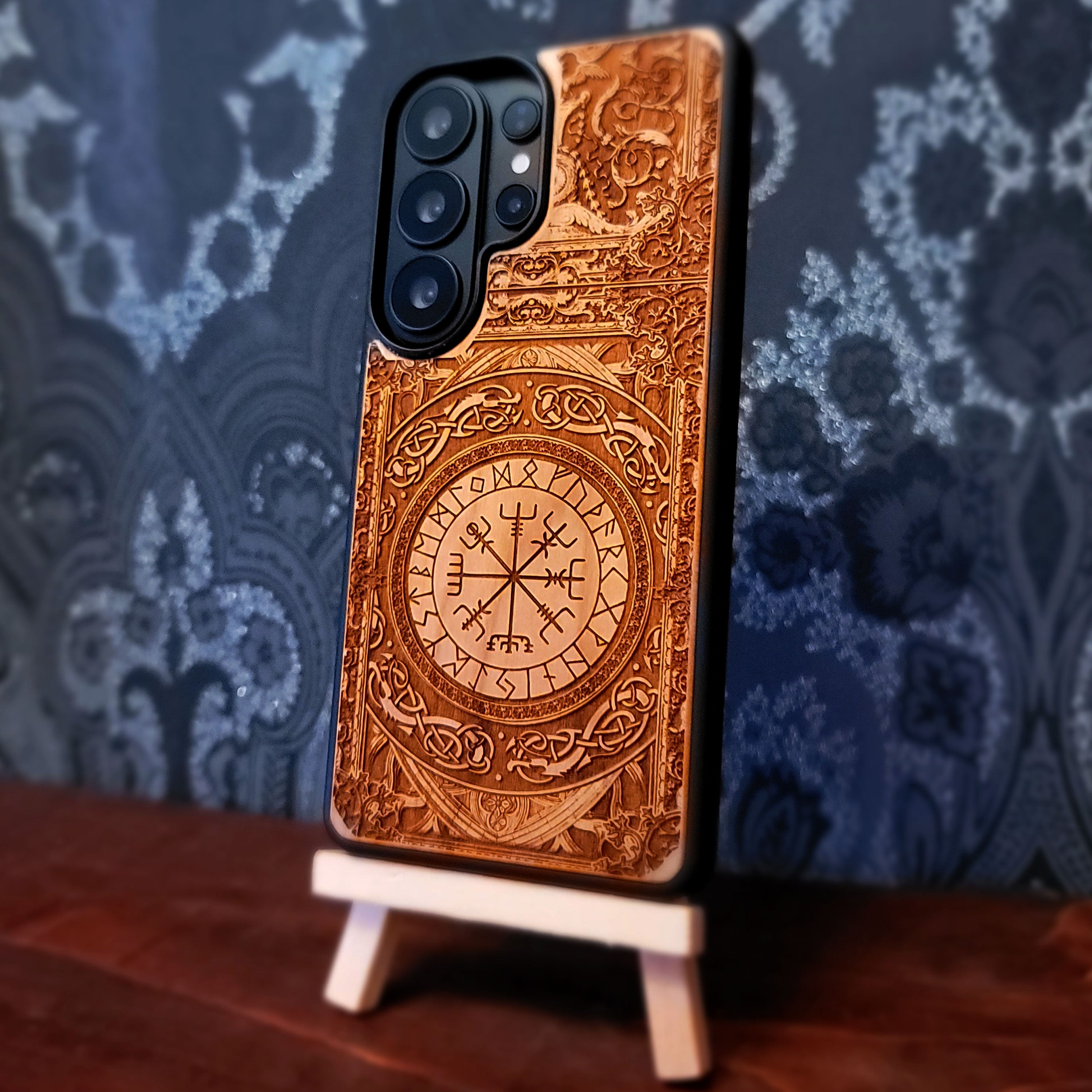 Deep laser engraved wooden phone case featuring the Vegvisir Viking compass with Nordic runic symbols for iPhone and Samsung Galaxy models.