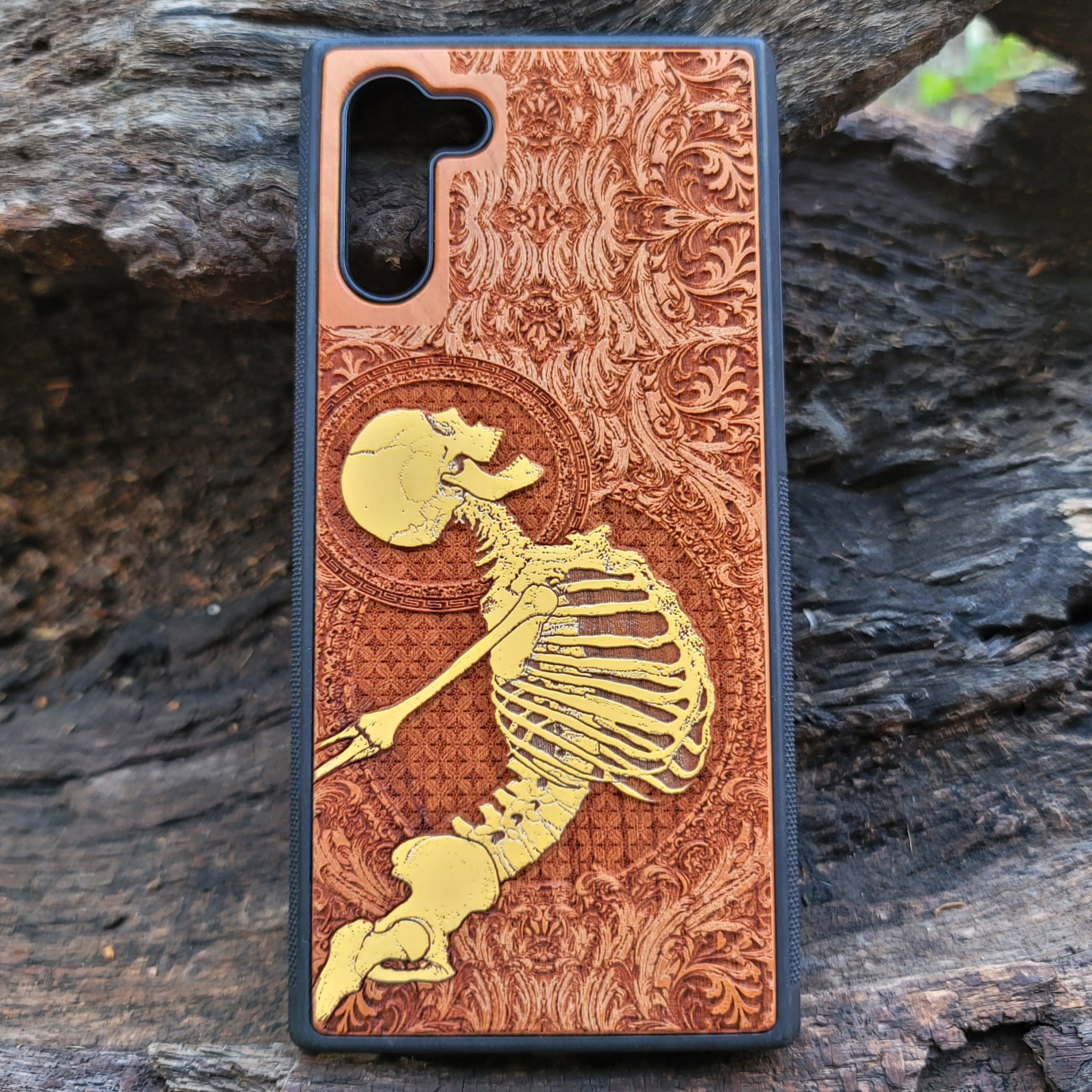 Cherry wood phone case with laser-engraved Gothic skeleton design for iPhone & Samsung Galaxy.