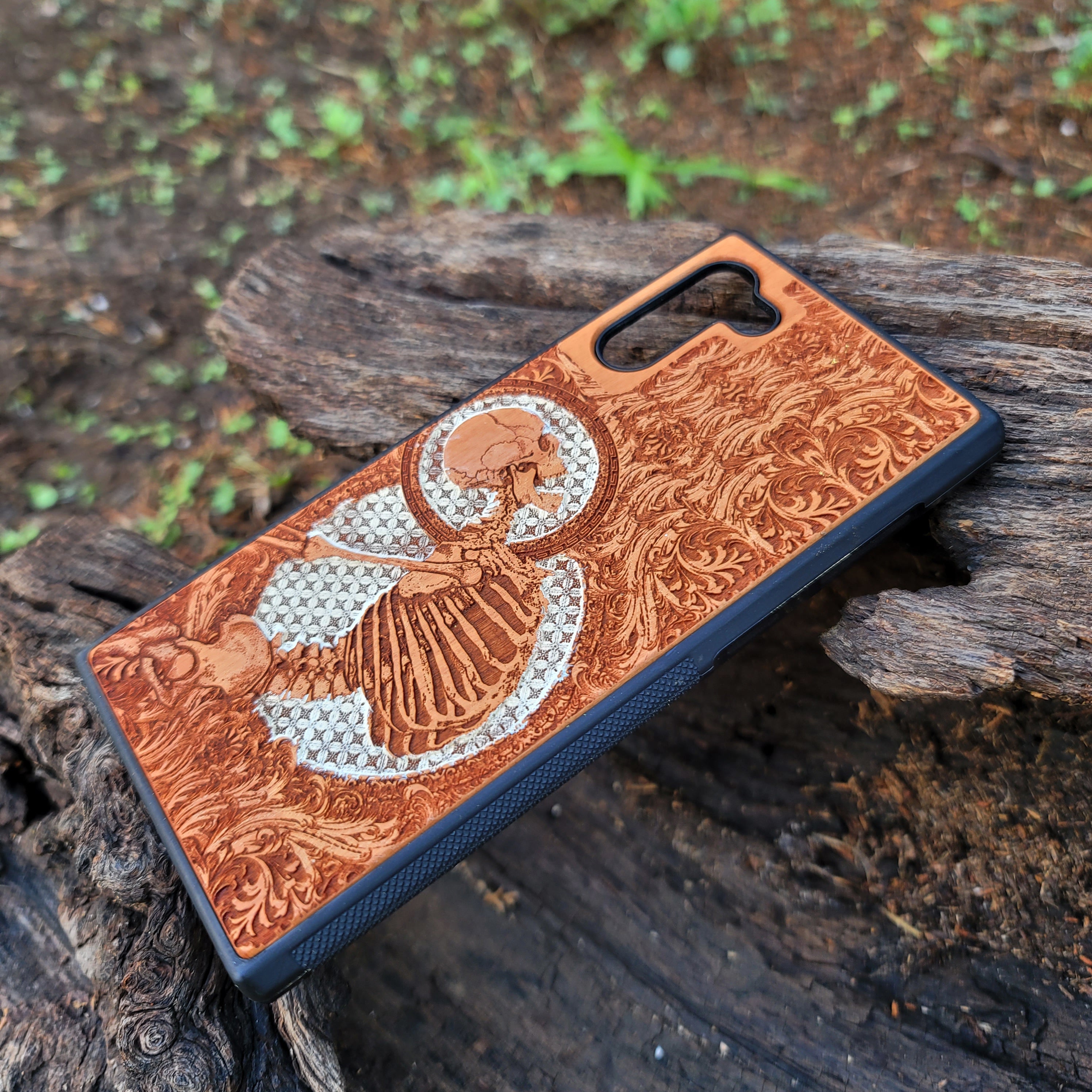 Gothic human skull with intricate details engraved on a wooden phone case, compatible with iPhone  and Samsung Galaxy S.