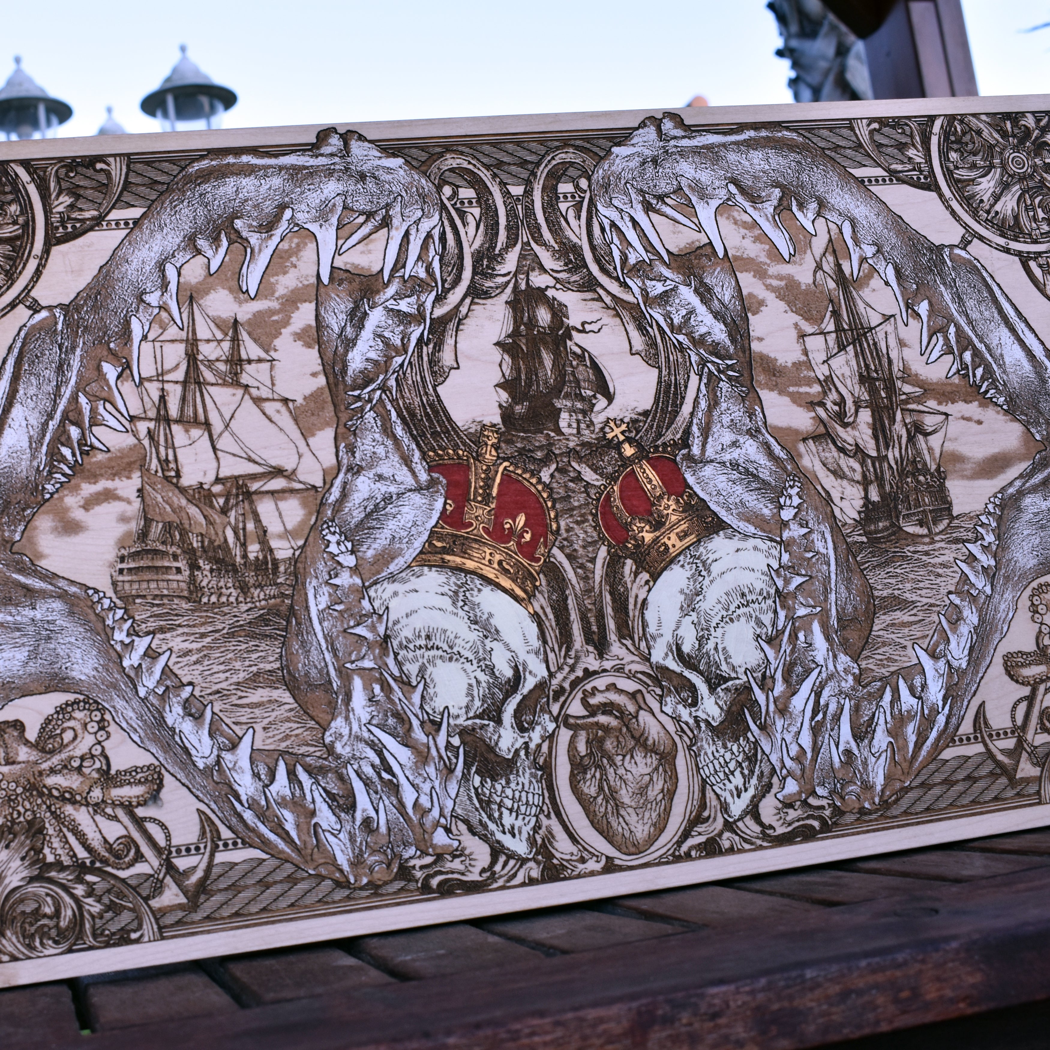 Extra-large shark jaw and pirate ship wood wall art, straight-on outdoor view of the nautical composition