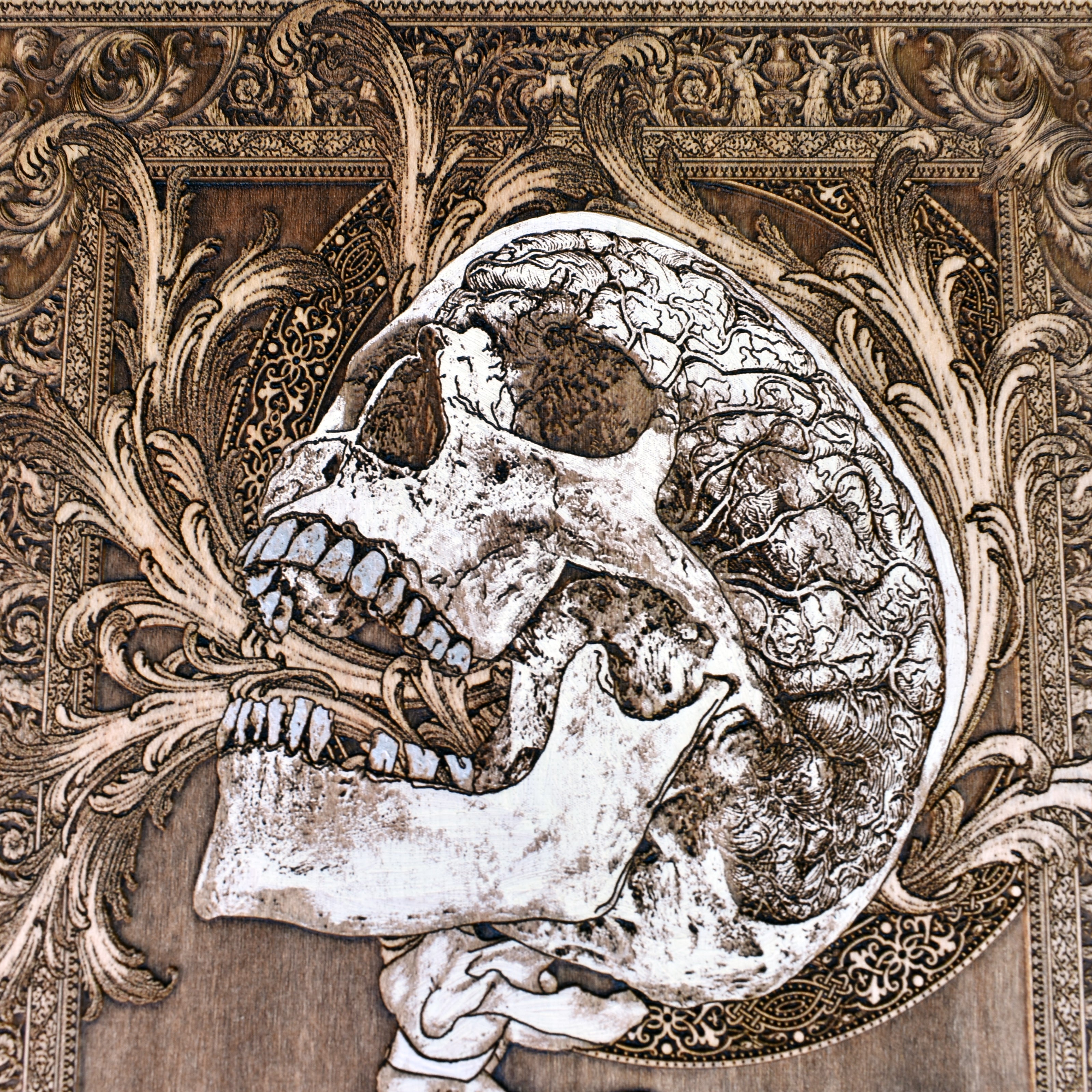 Gothic wall art plaque with screaming skull and anatomical spine design.