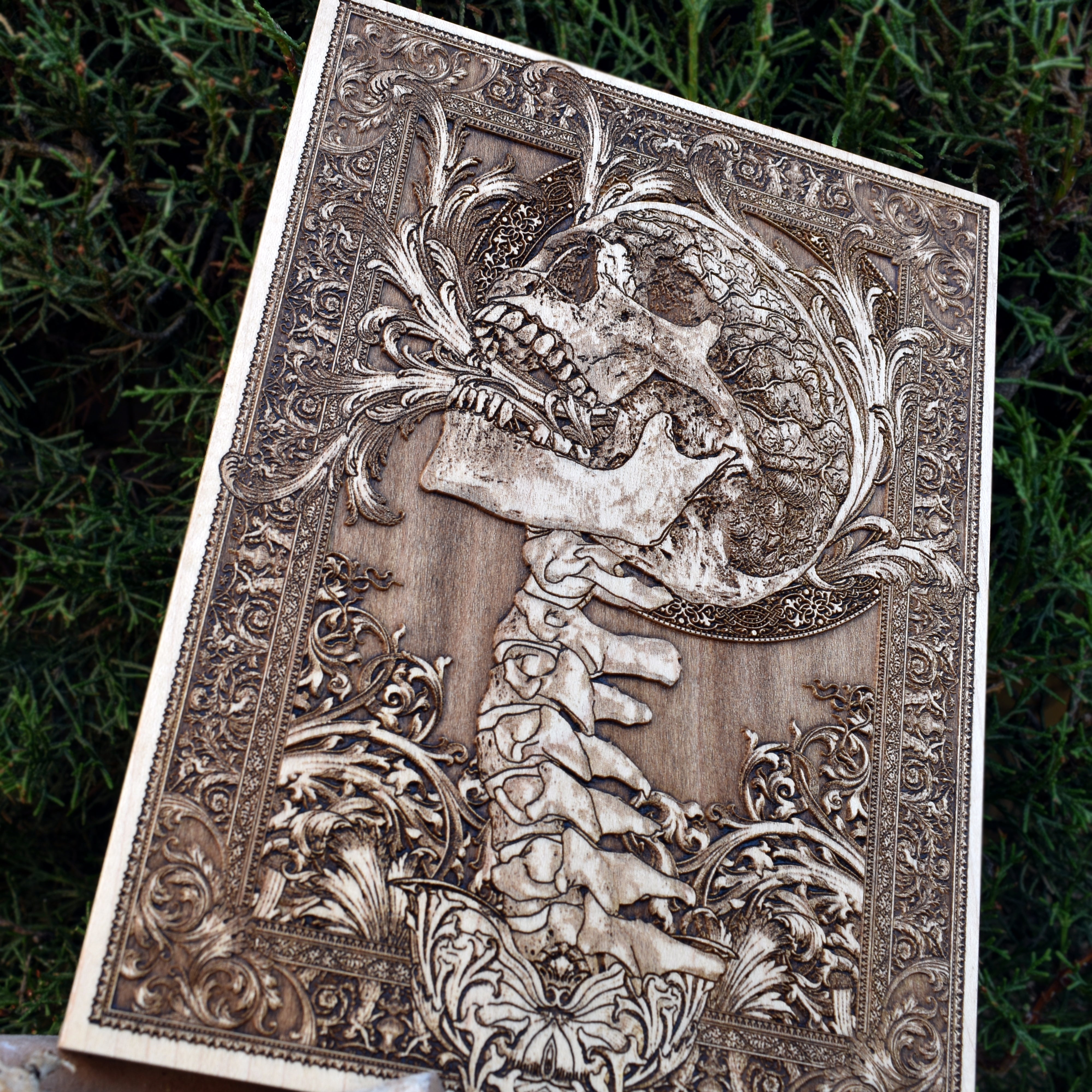 Handcrafted wooden skull artwork featuring a detailed human spine engraving, ideal for gothic home decor and unique dark art gifts.